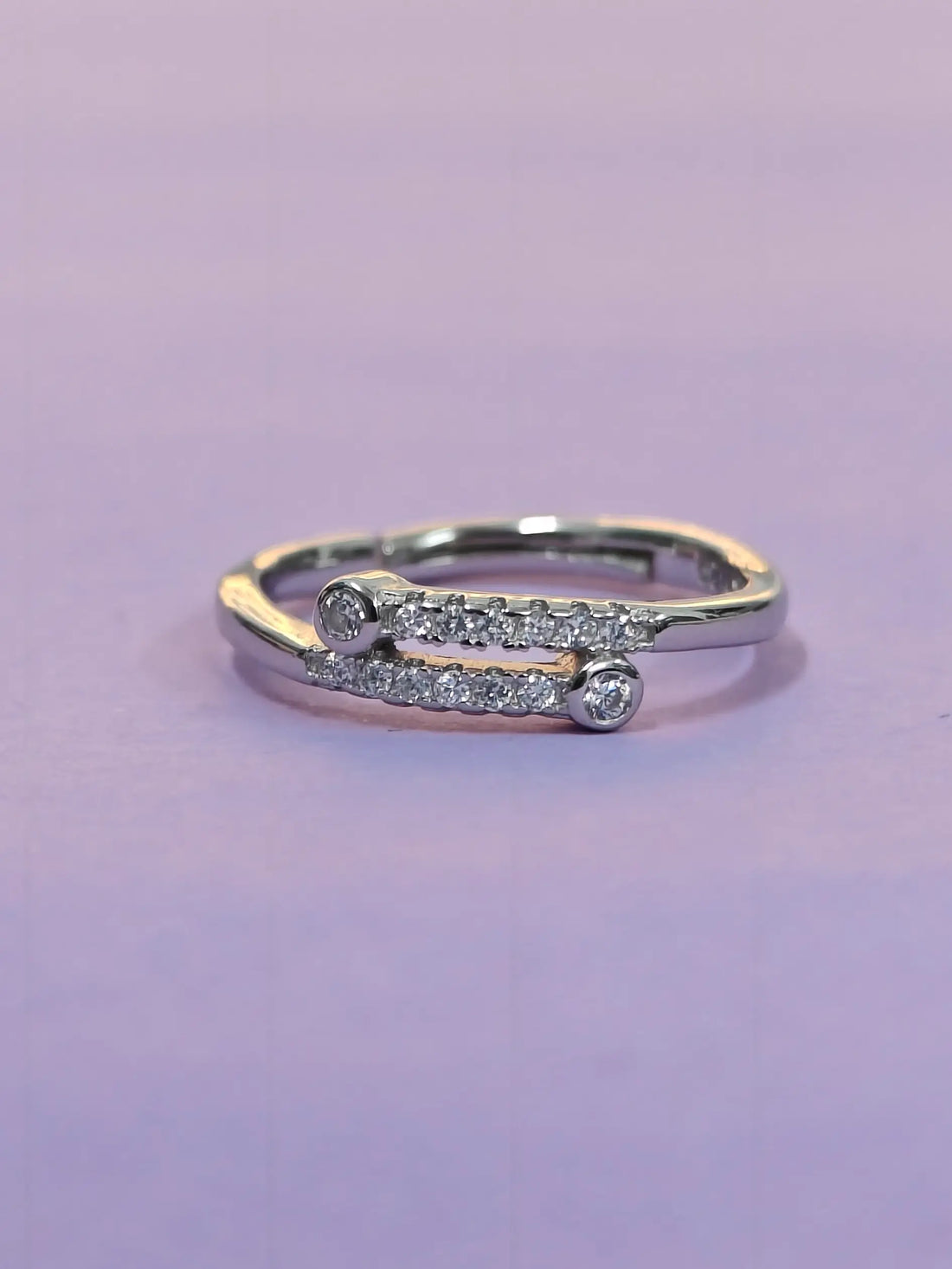 Gold and silver ring with diamonds on a purple background