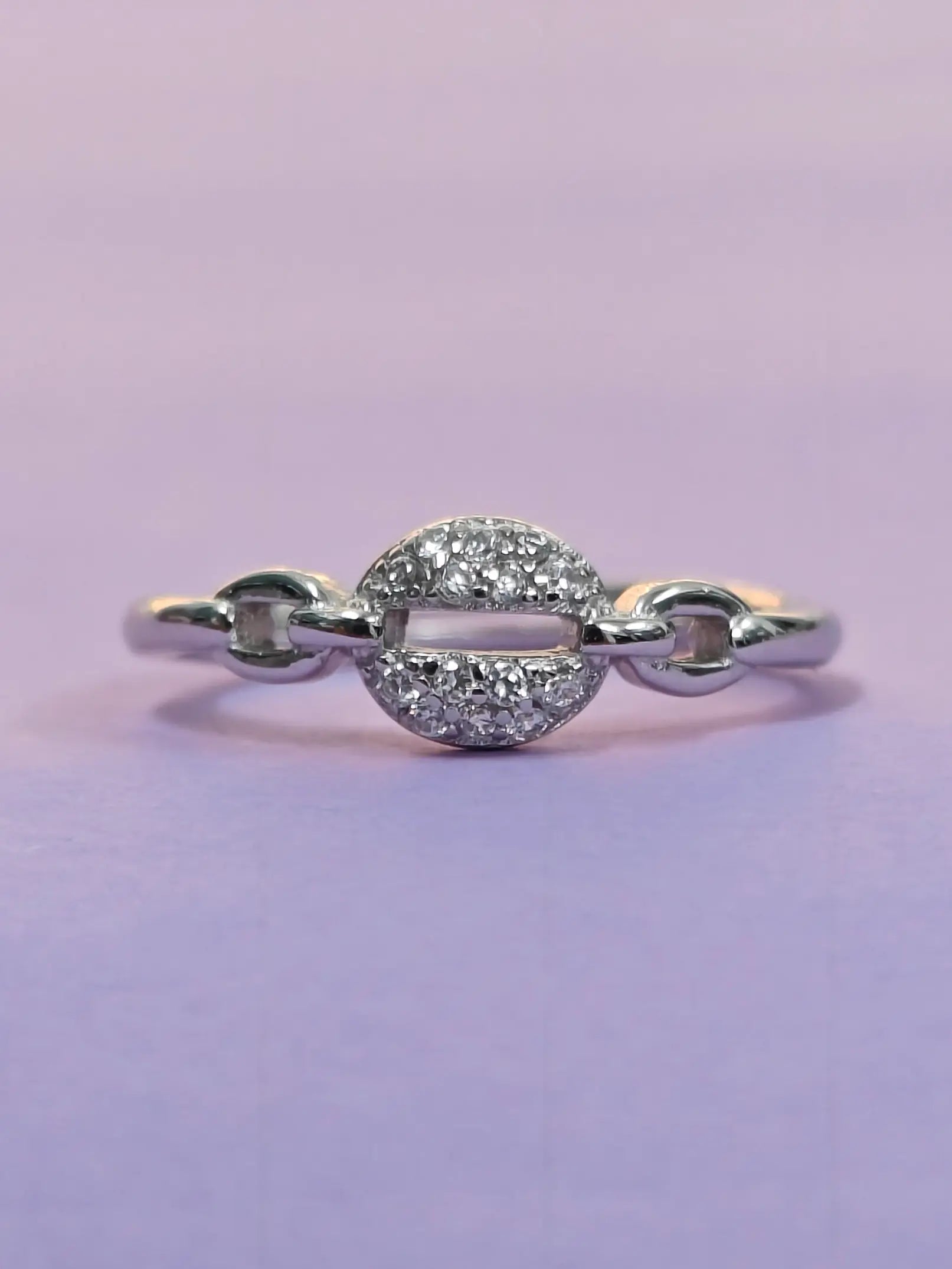 Silver ring with gemstones on a purple background