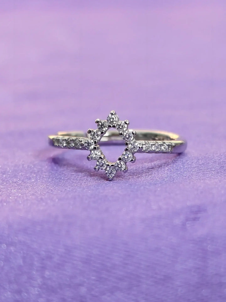 Silver ring with star design on a purple background