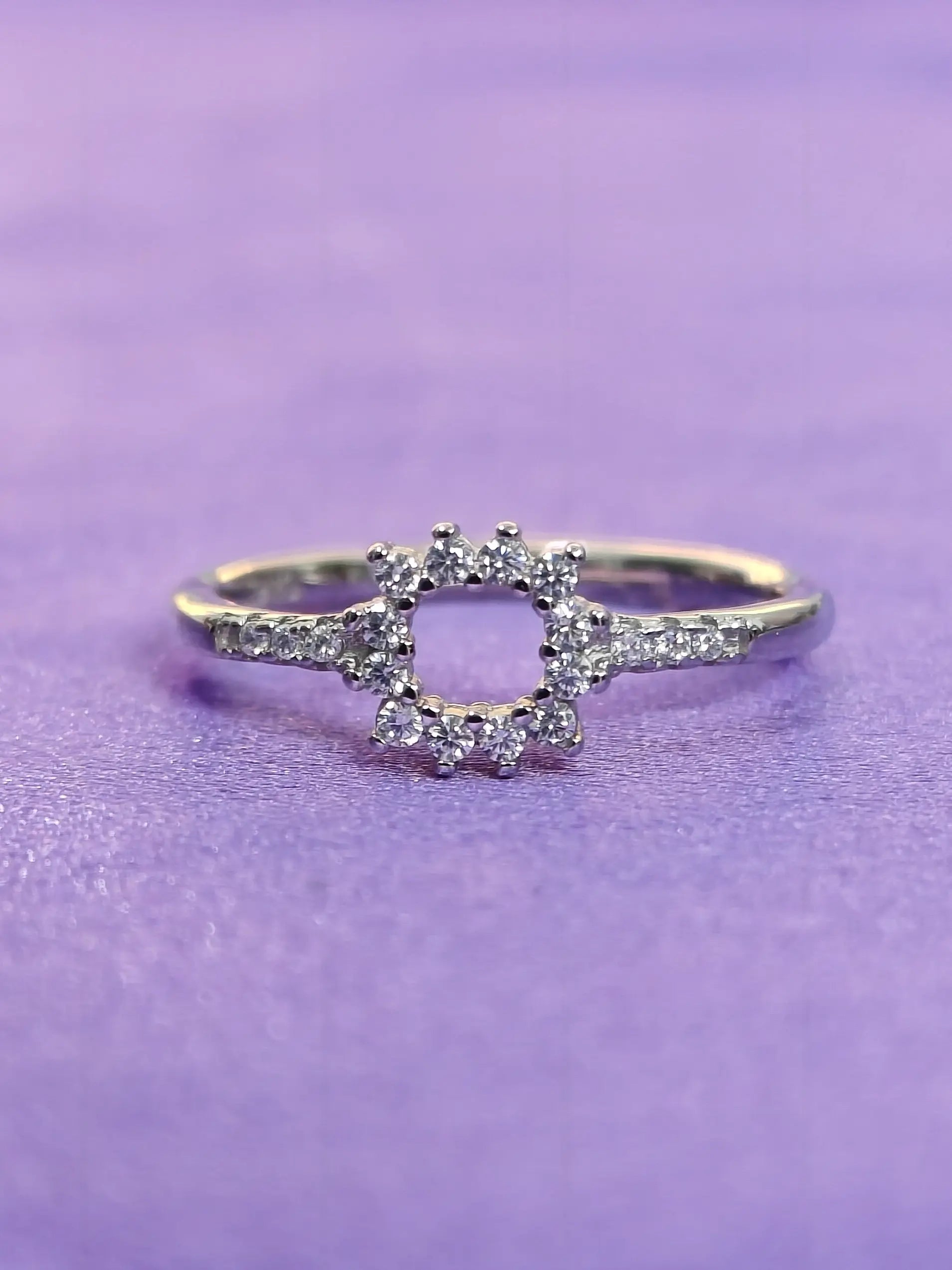 Silver ring with a diamond design on a purple background