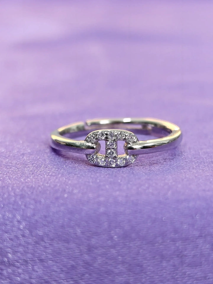 Silver ring with a diamond on a purple fabric background
