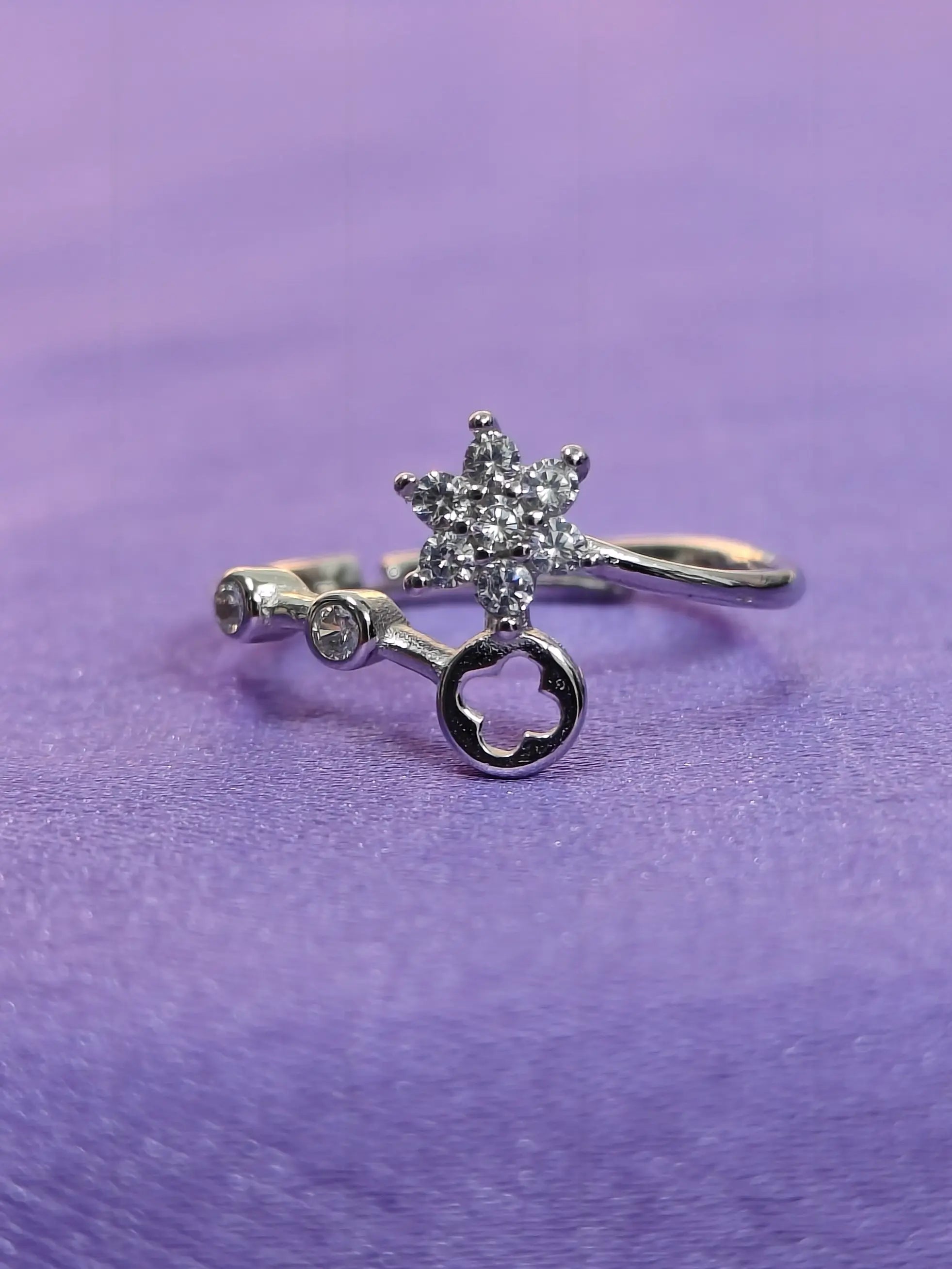 Silver ring with star-shaped gemstone on a purple background