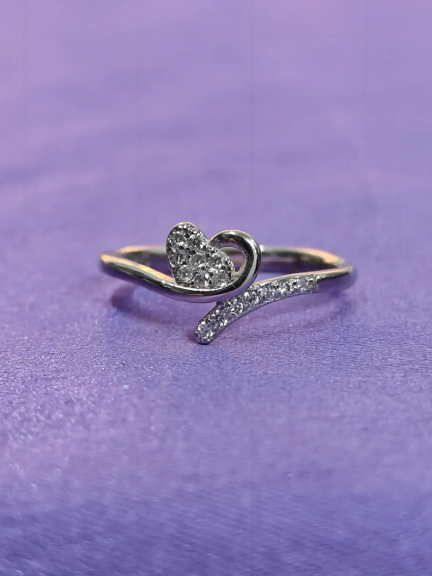 Silver heart-shaped ring on a purple background