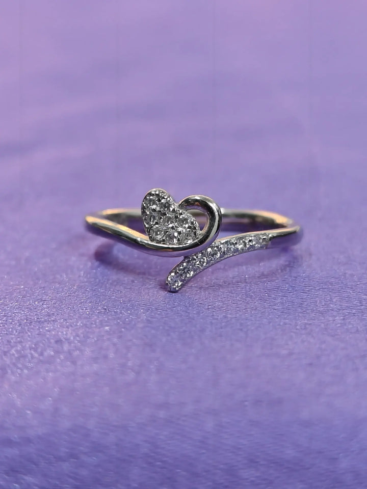 Silver heart-shaped ring on a purple background