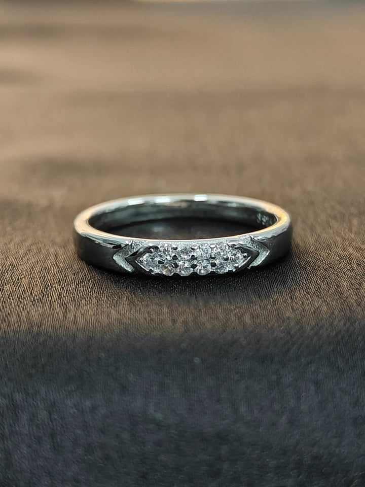 Silver ring with gemstones on a brown fabric background