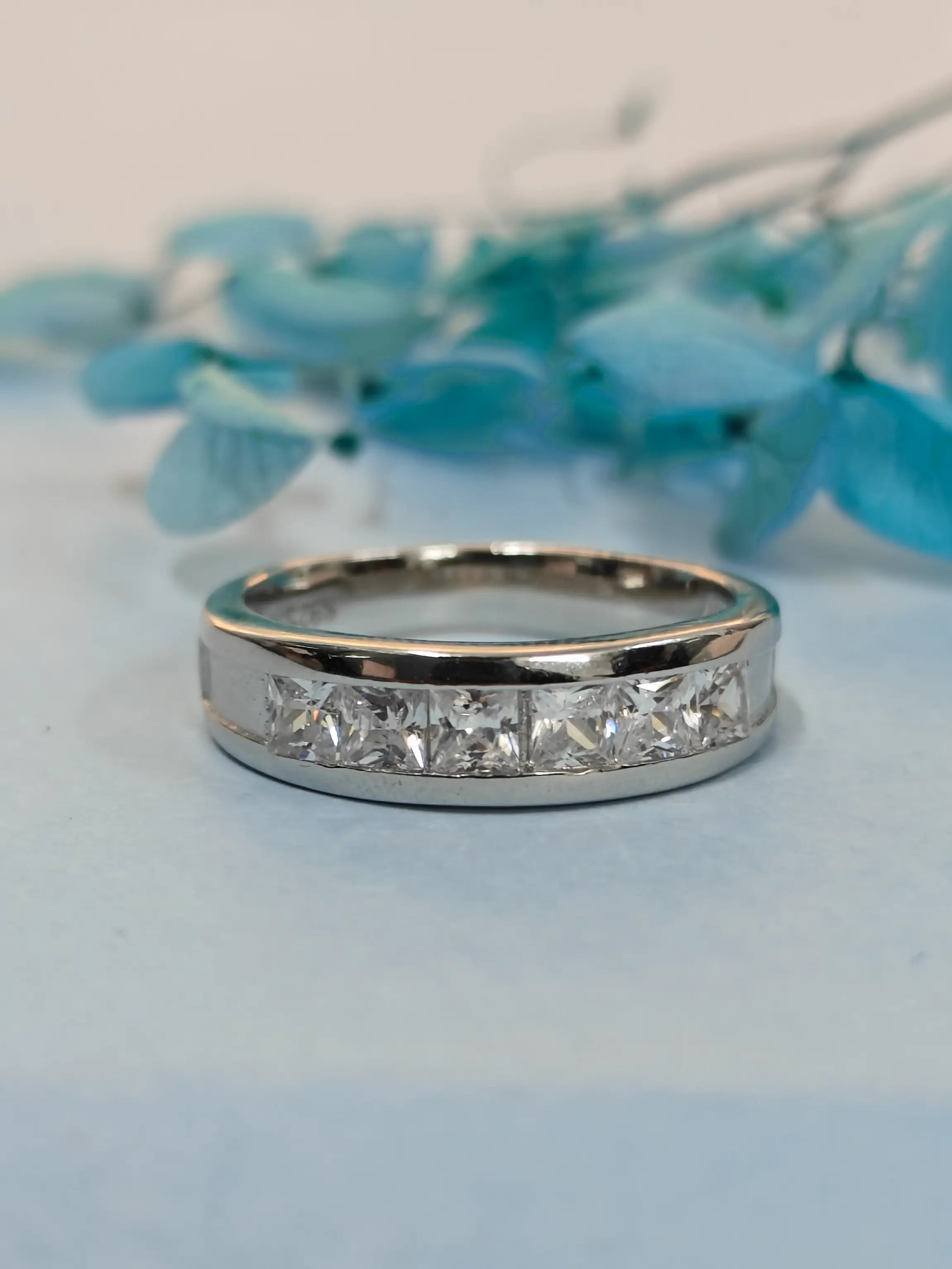 Silver ring with diamonds on a light blue background