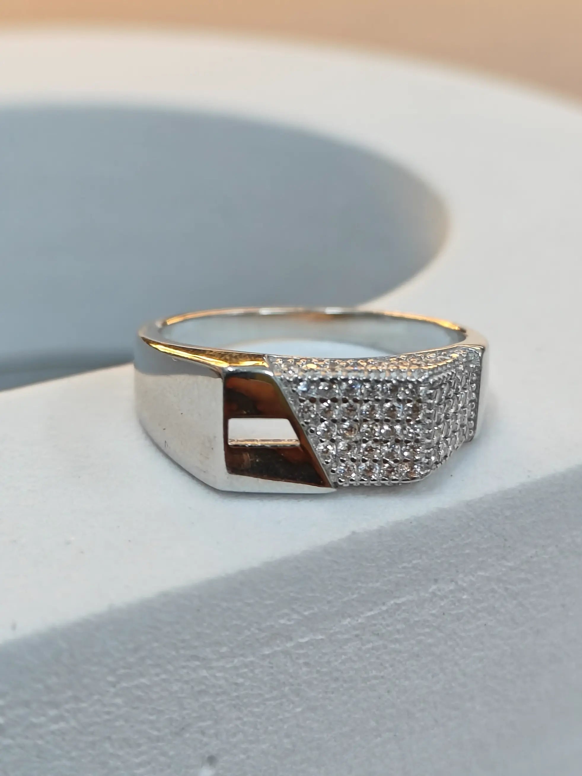 Silver ring with a textured band on a light gray surface