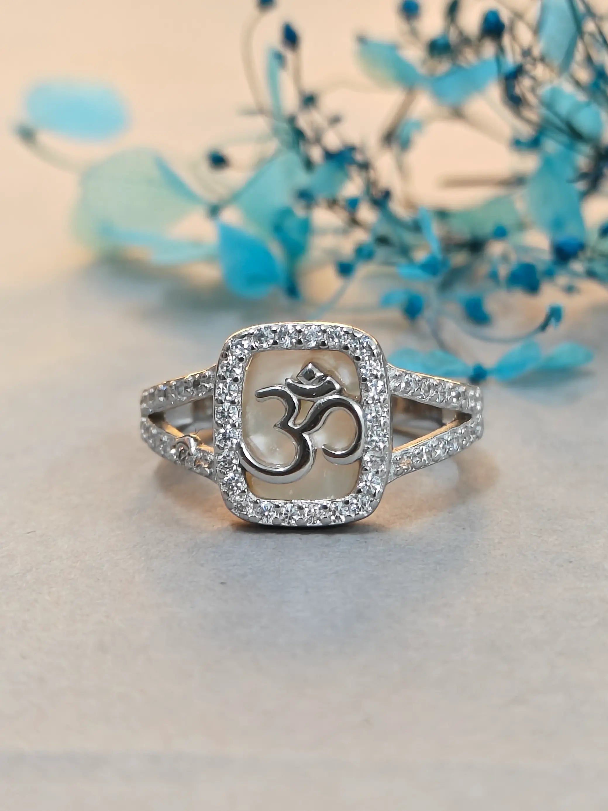 Silver ring with Om symbol on a light background