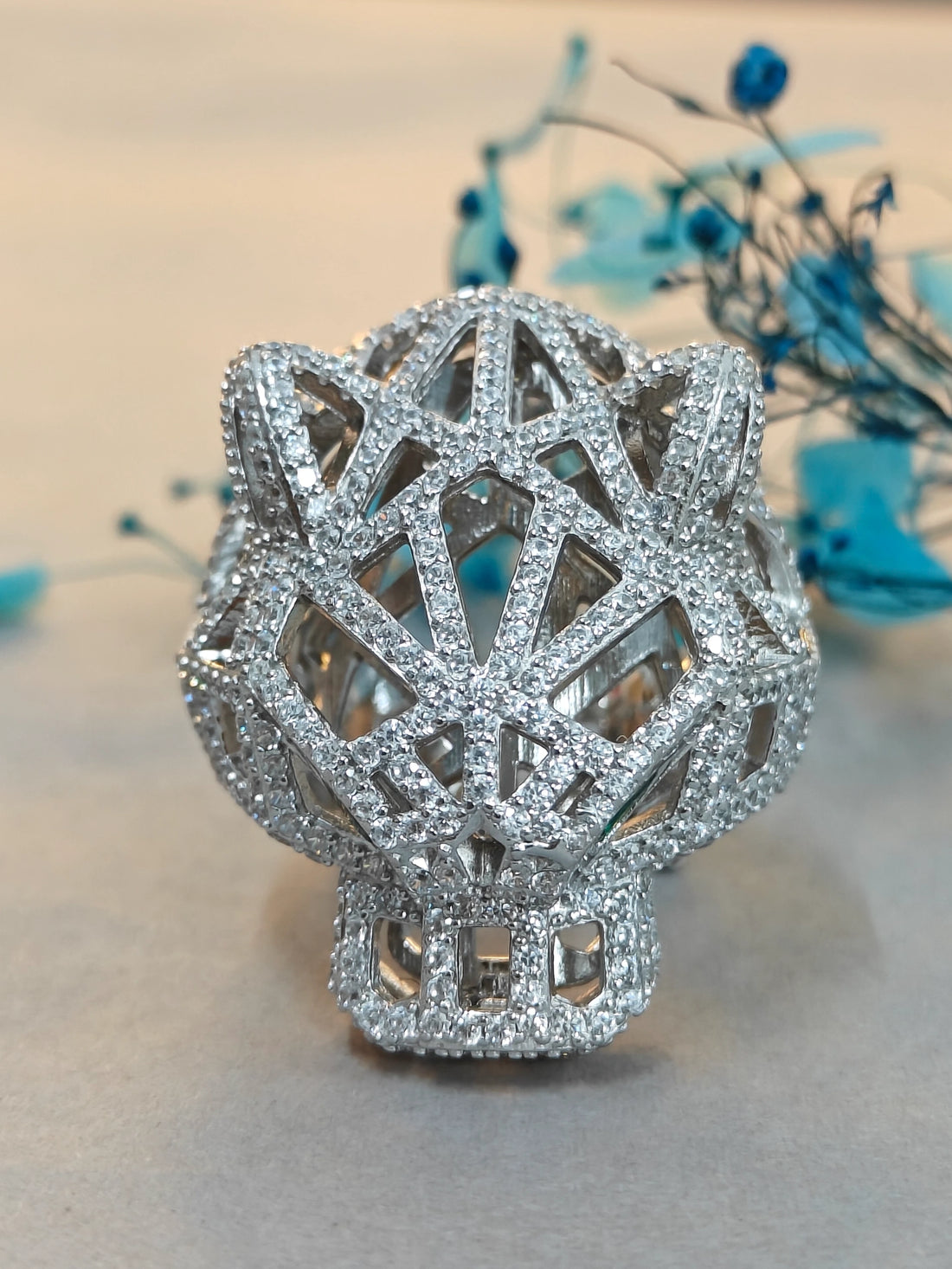 Silver decorative object with geometric design on a neutral background