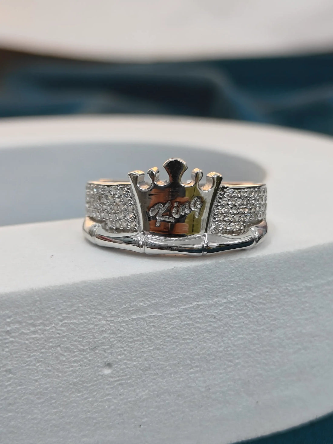 Silver ring with 'King' engraving on a gray surface