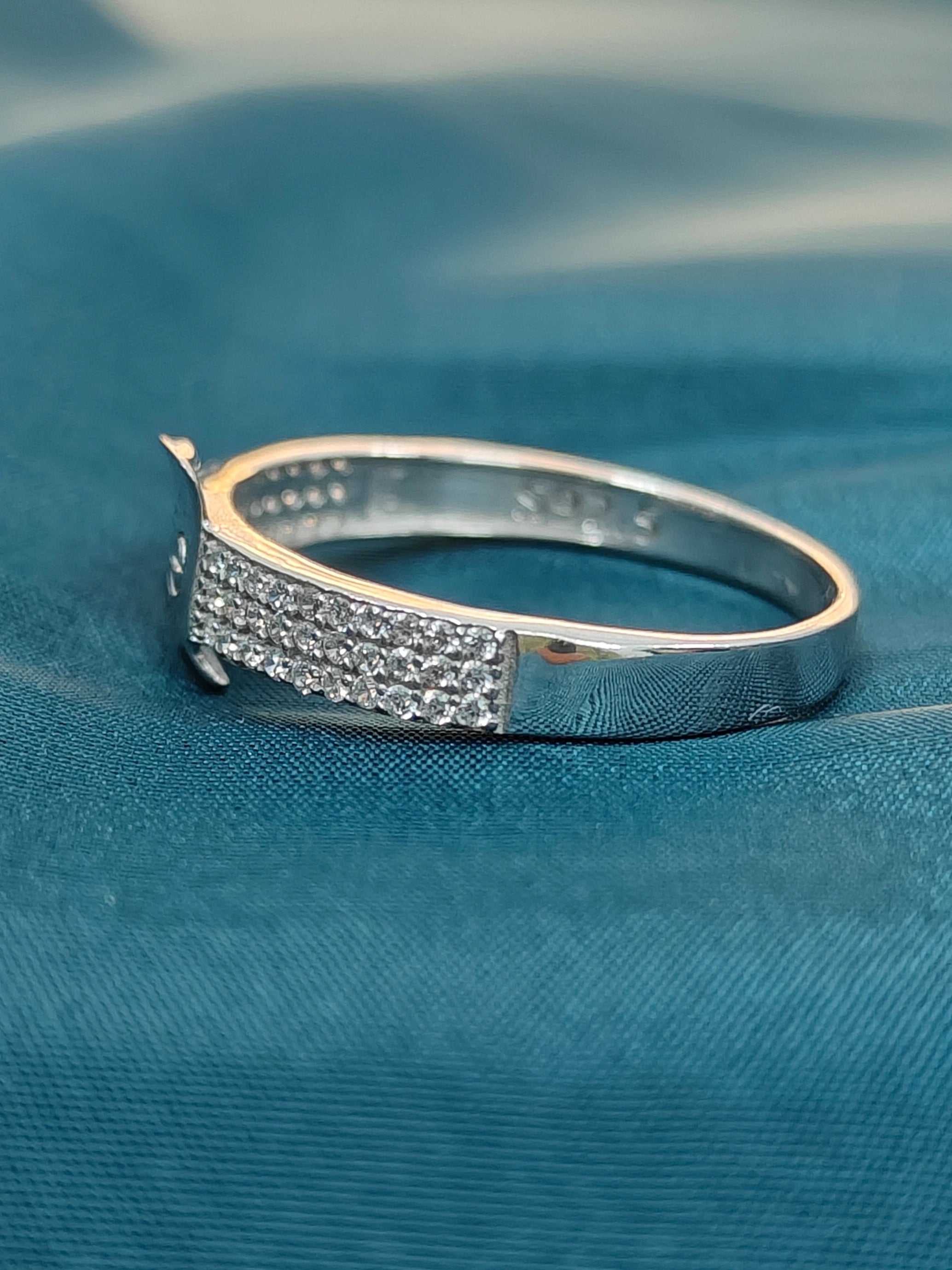 Silver bracelet with diamond accents on a blue fabric background