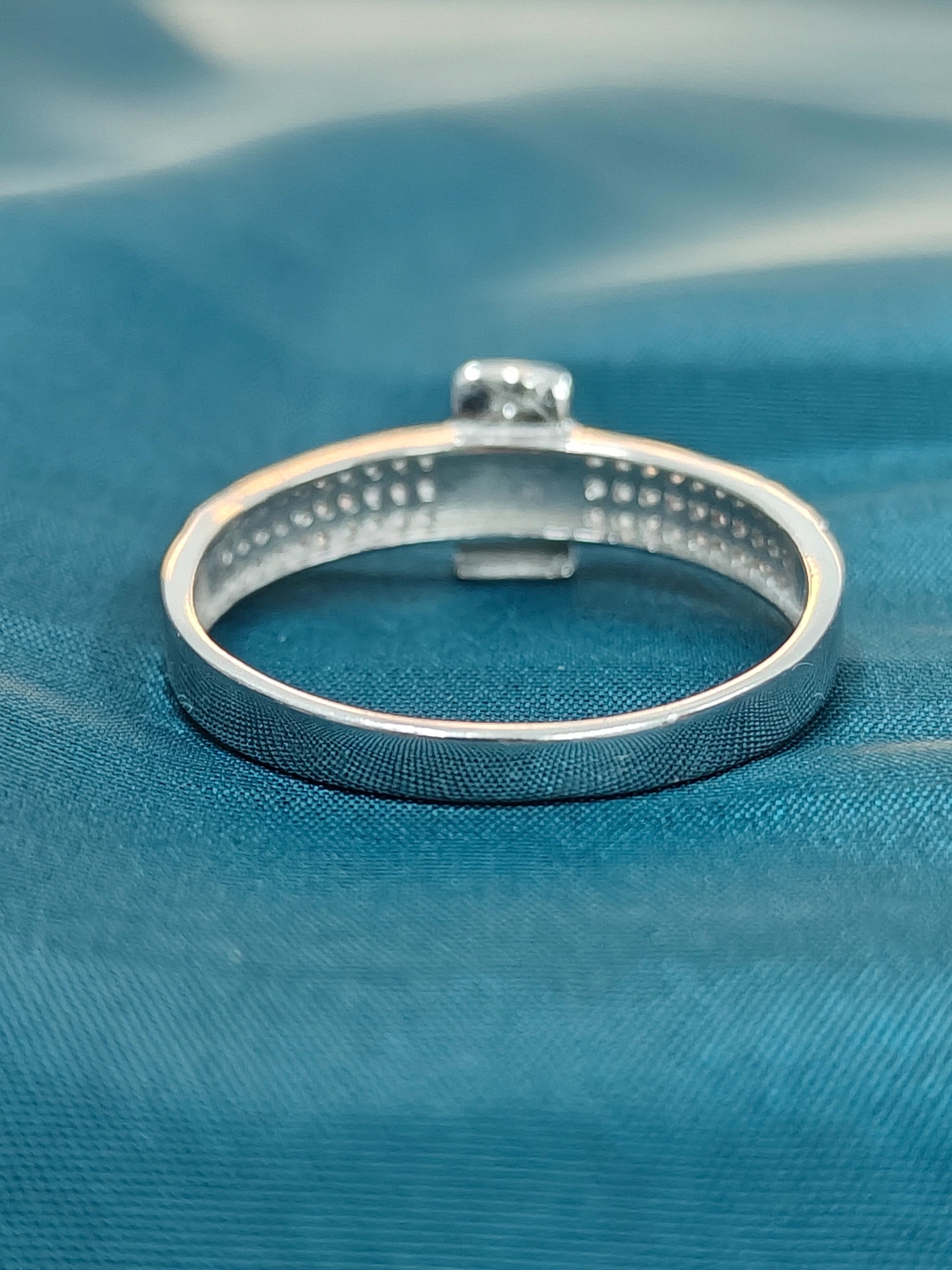Silver ring on a blue fabric background