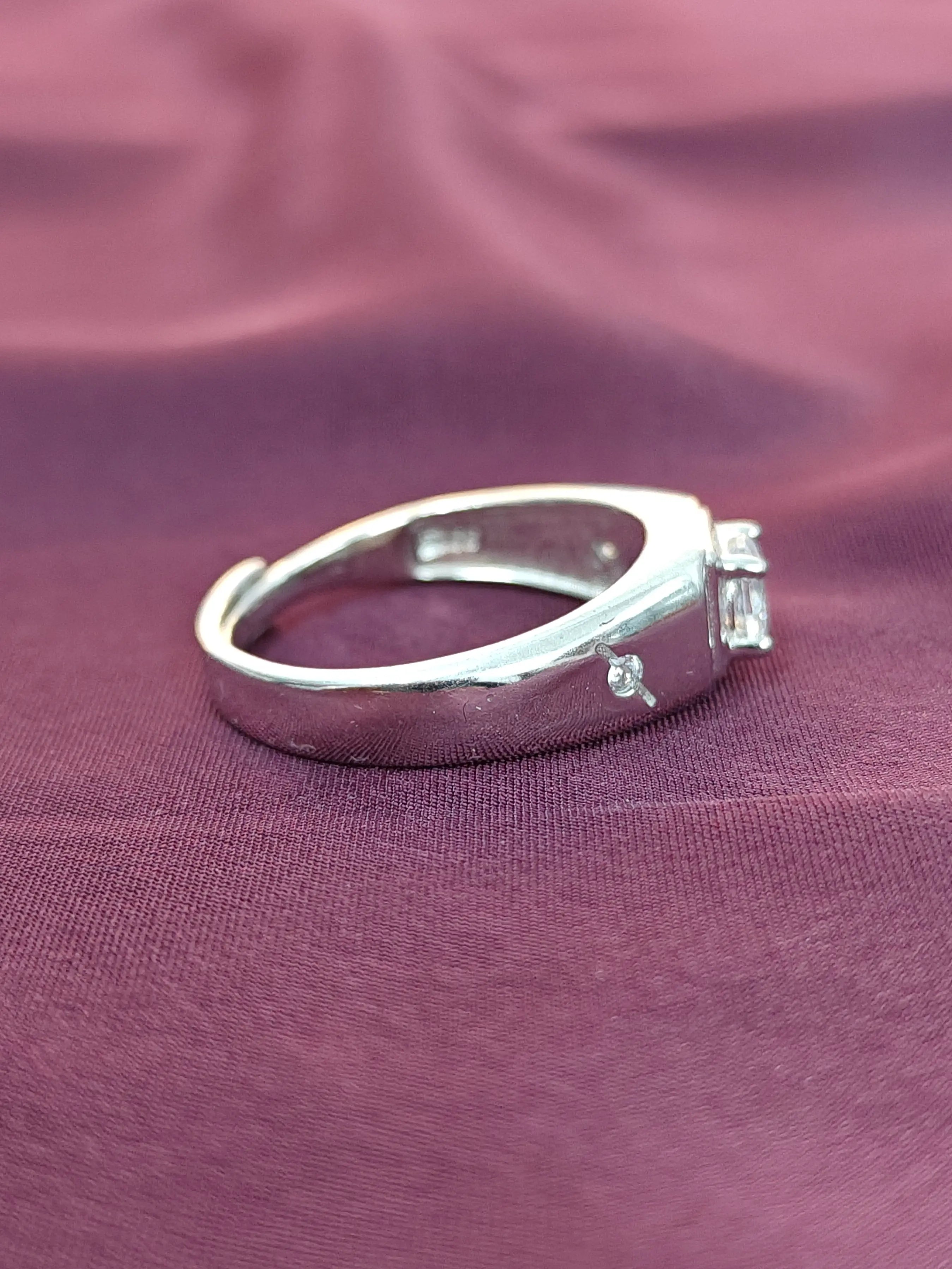 Silver ring with diamonds on a purple fabric background