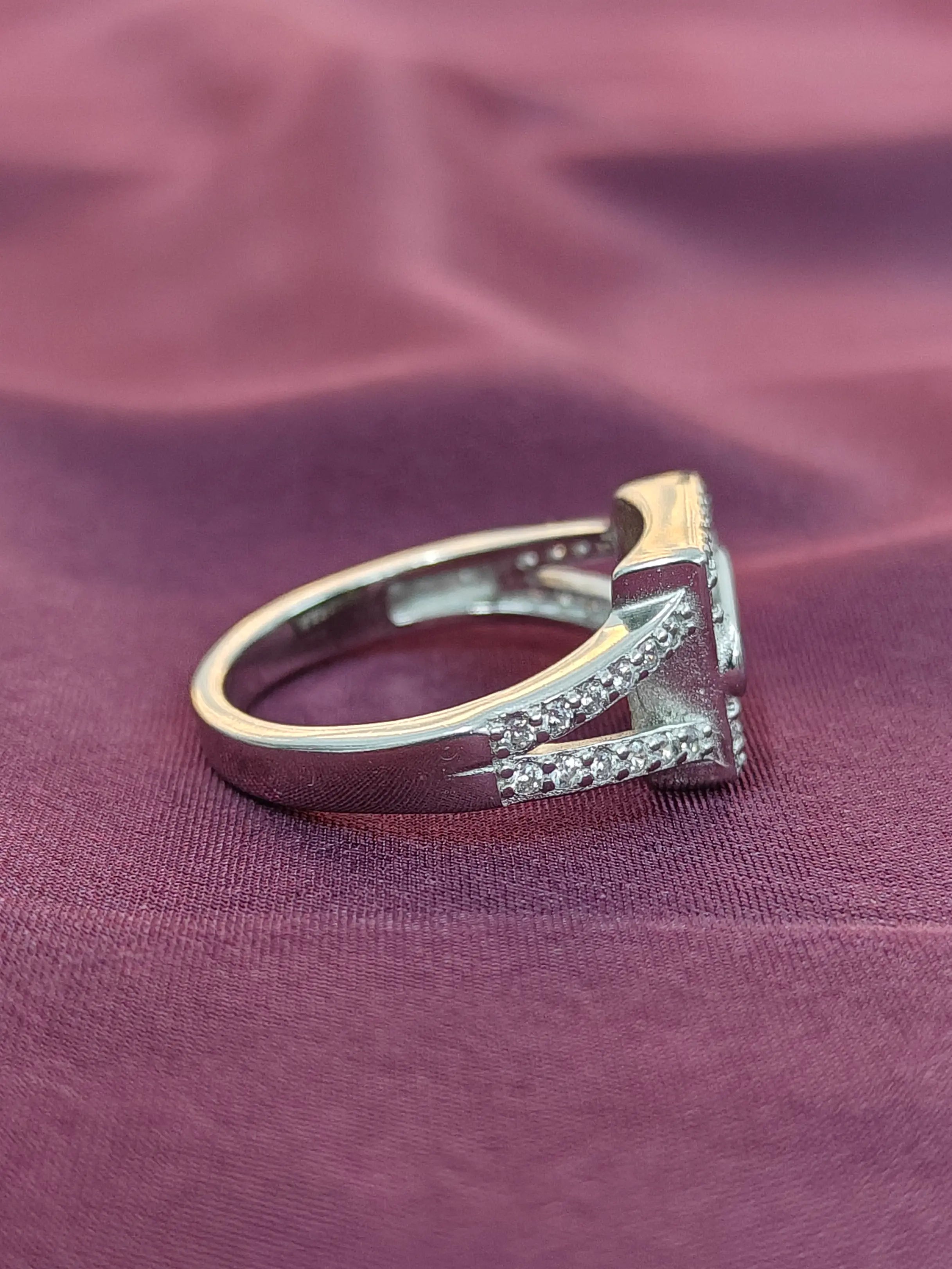 Gold and silver ring with diamonds on a purple fabric background