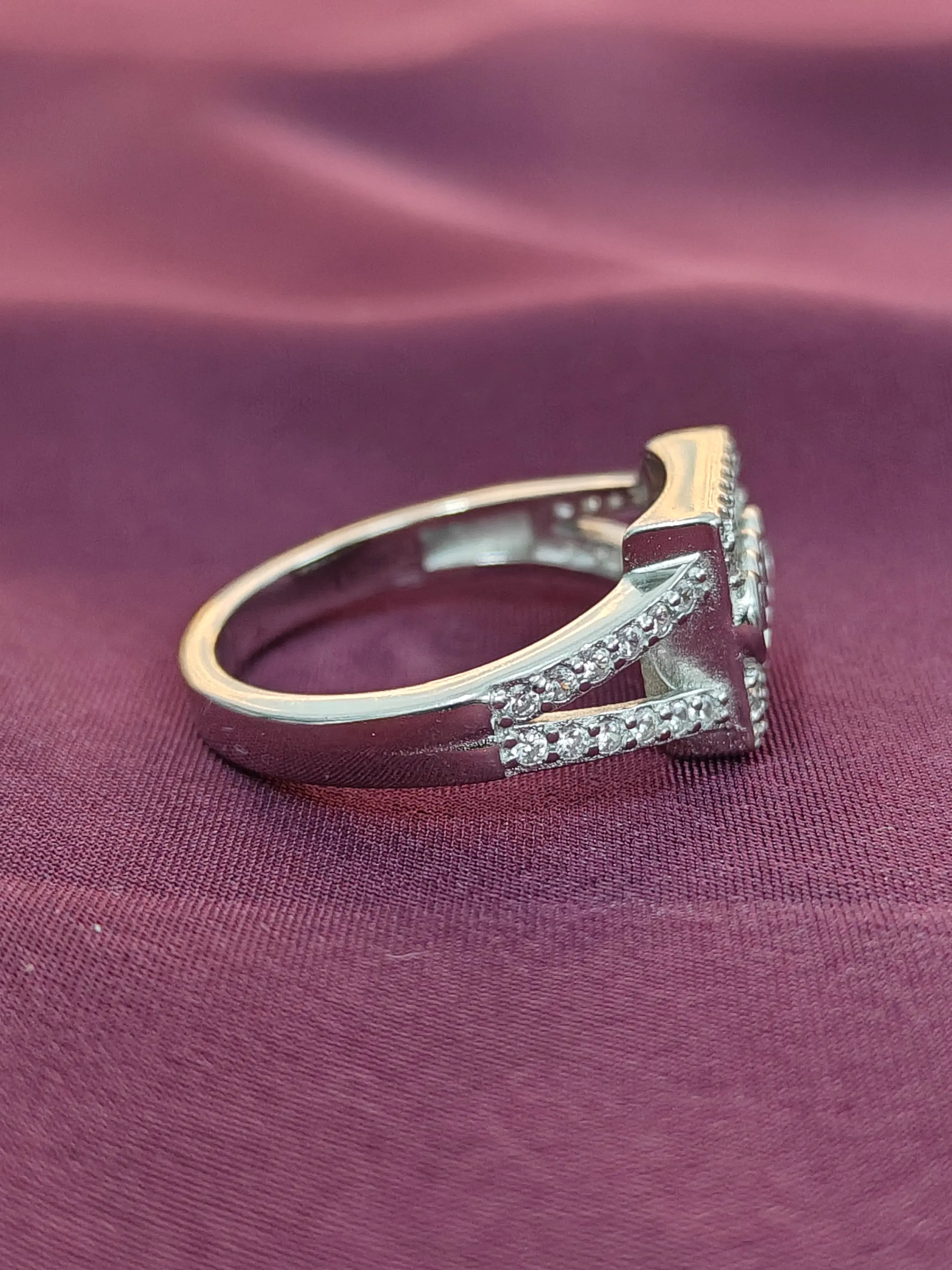 Gold ring with diamonds on a purple fabric background