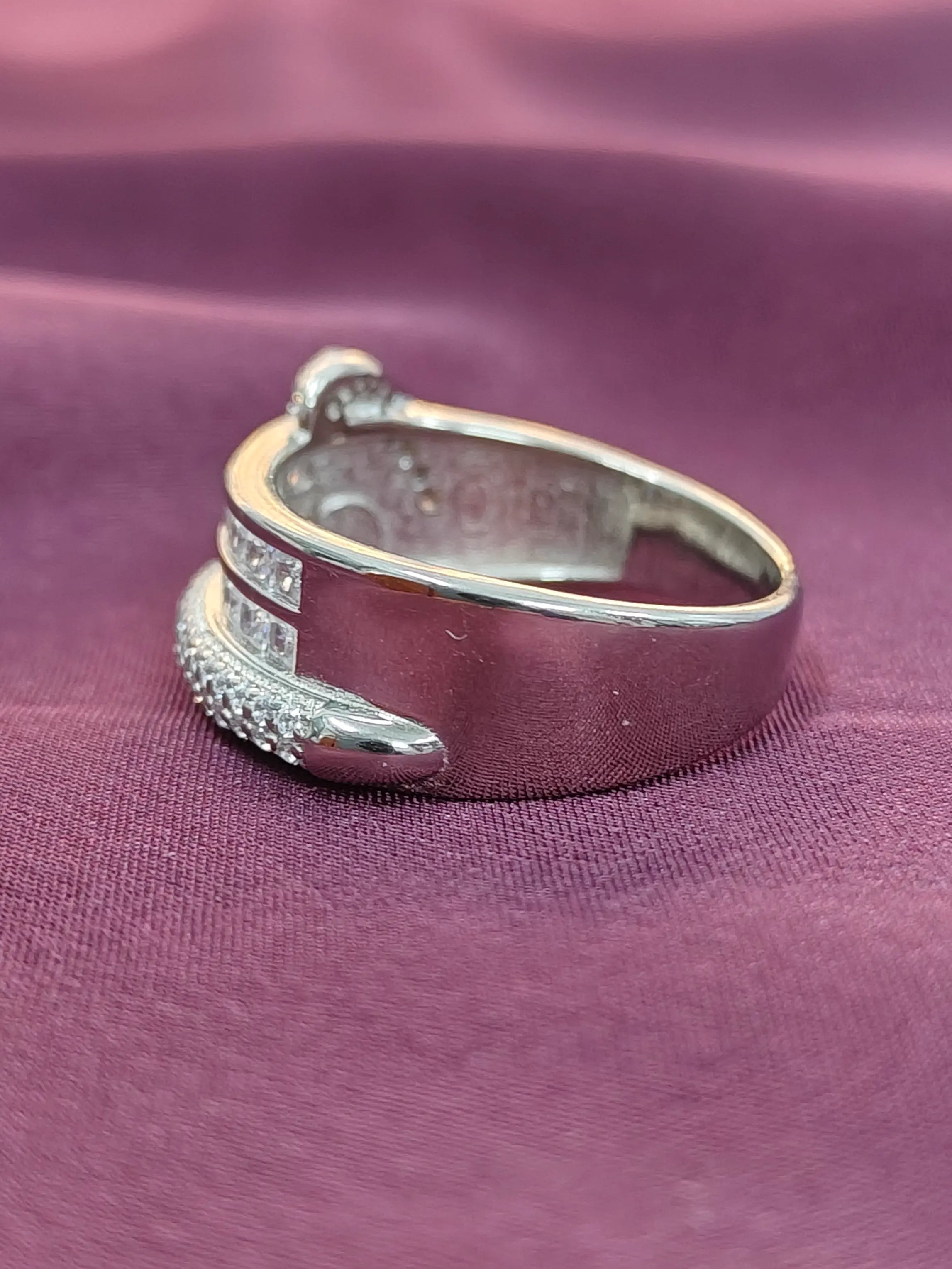 Silver ring with gemstones on a purple fabric background
