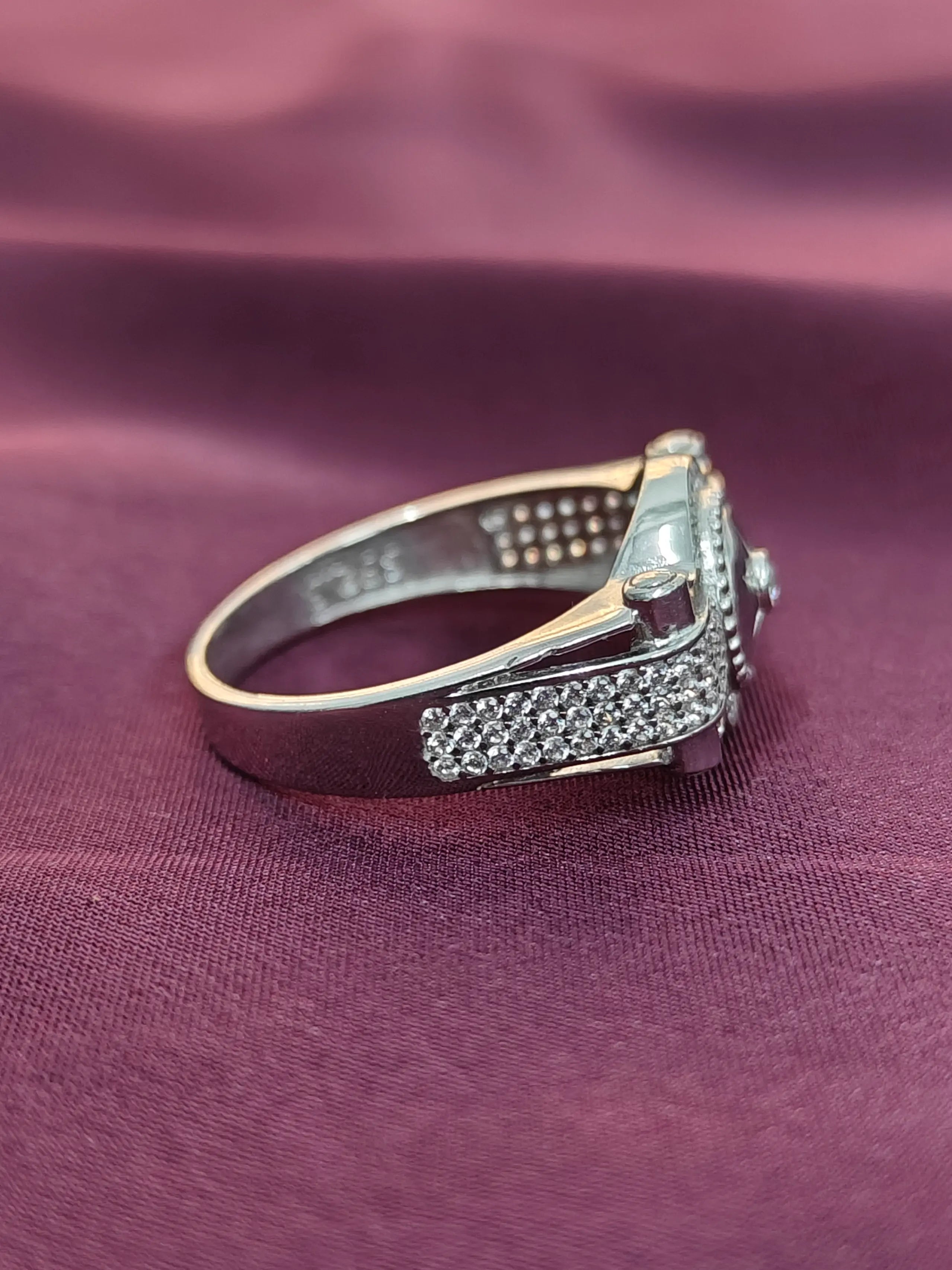 Silver ring with gemstones on a purple fabric background