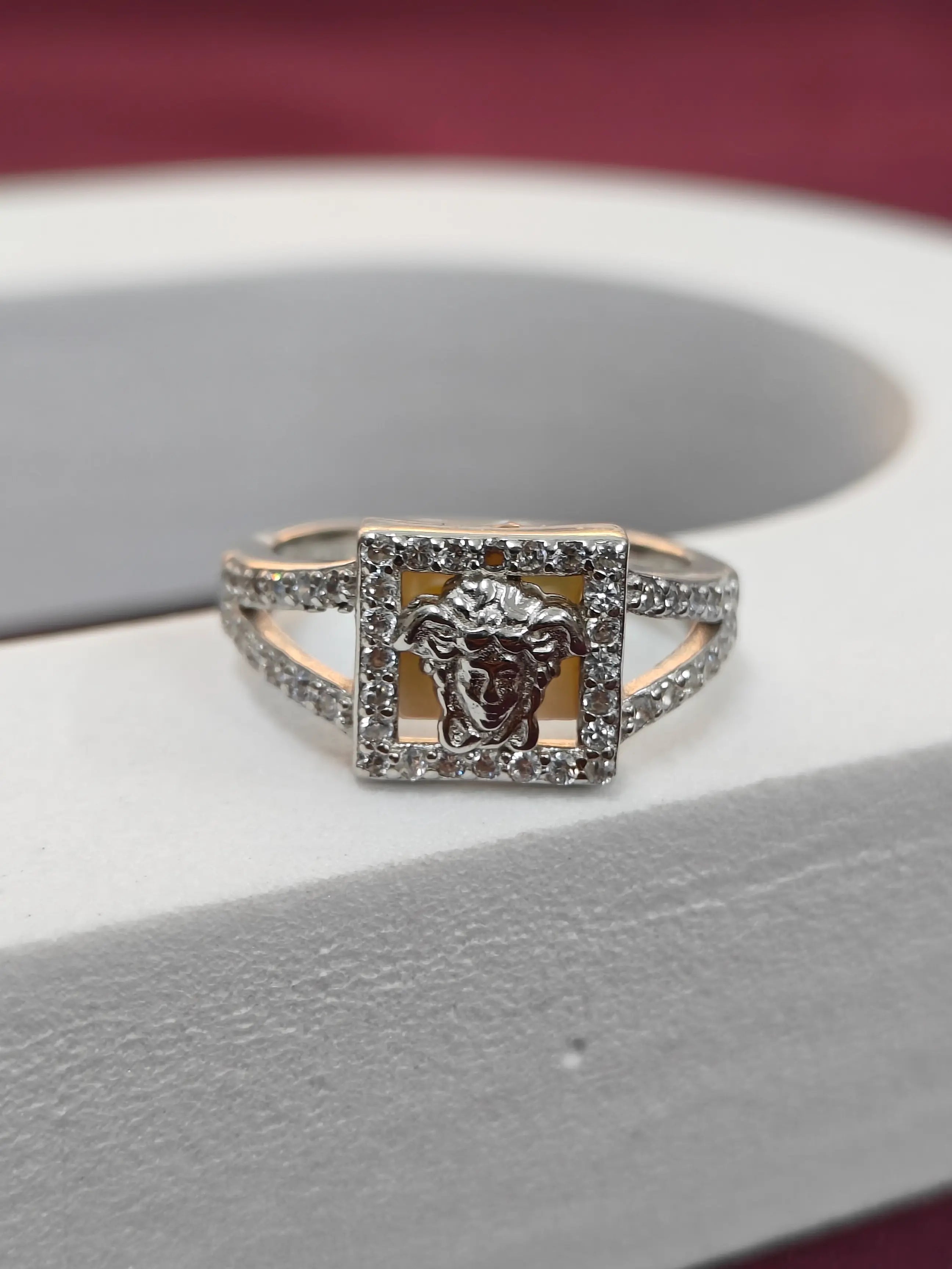 Silver ring with a square design on a gray surface