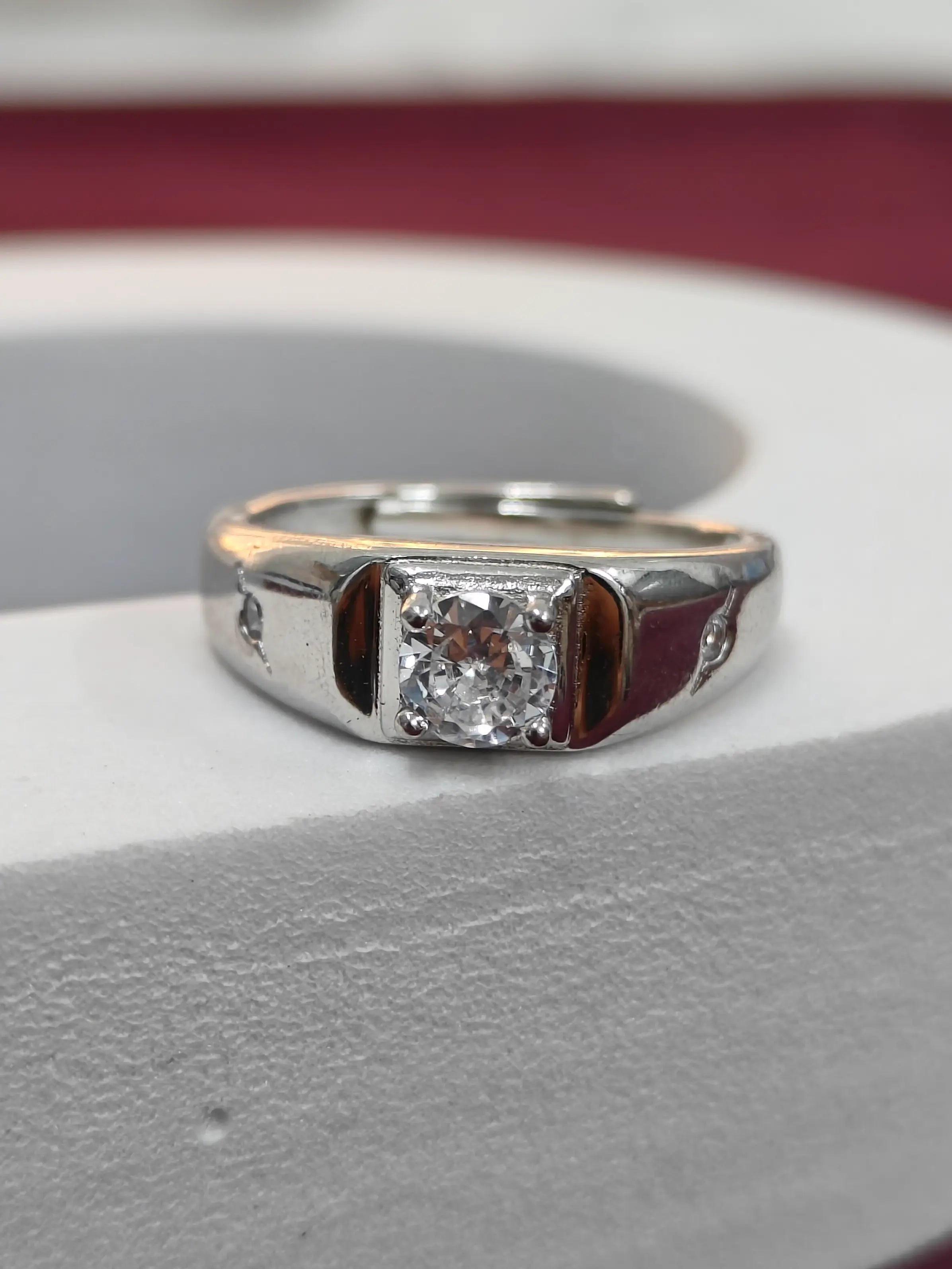 Silver ring with a diamond on a gray surface