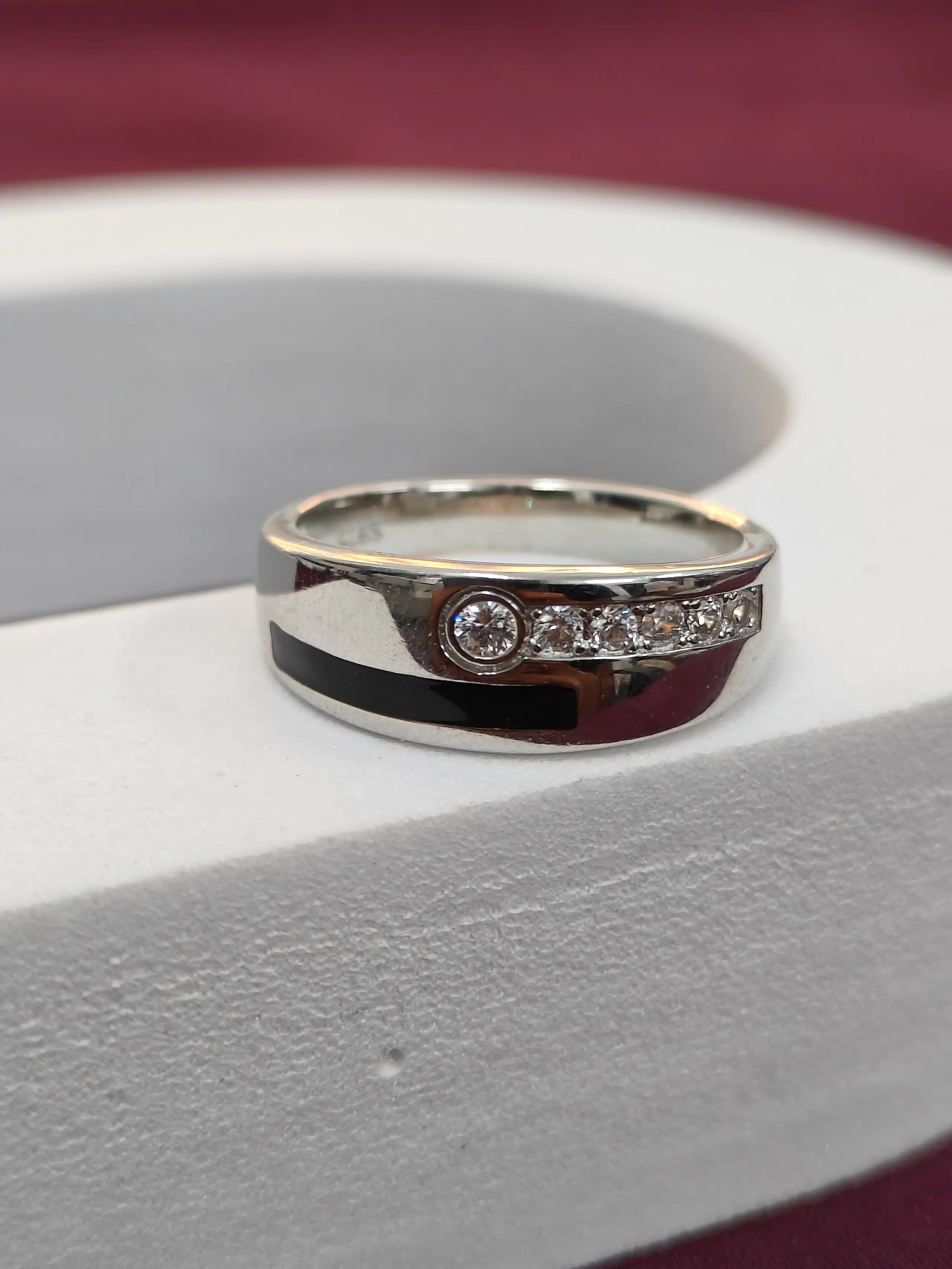 Silver ring with small diamonds on a white surface
