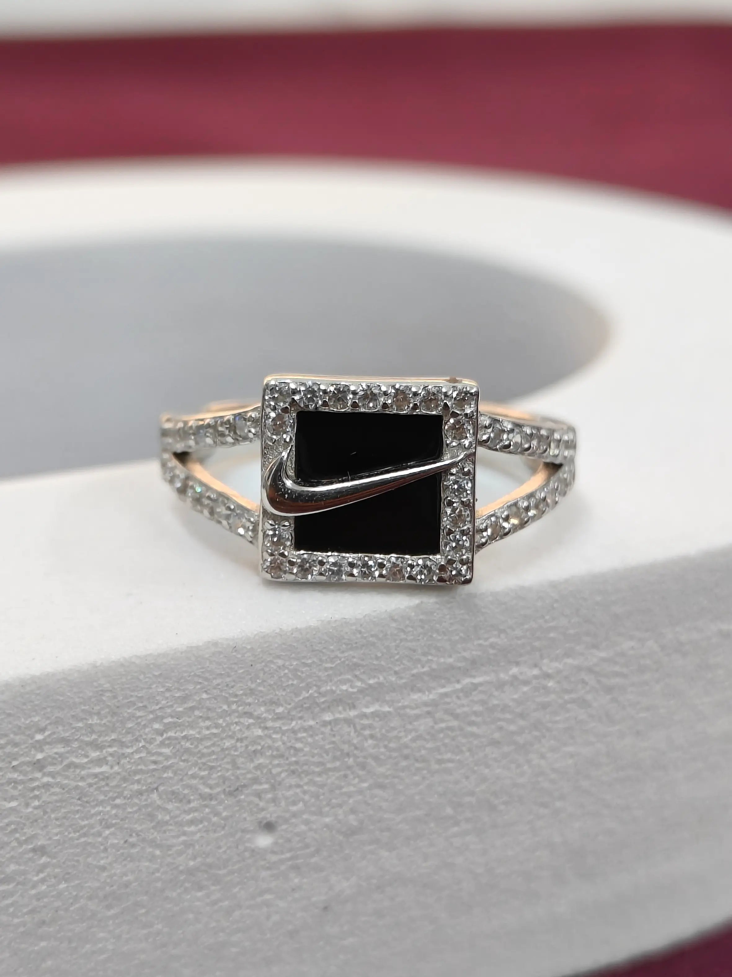 Ring with black center and rose gold accents on a white surface