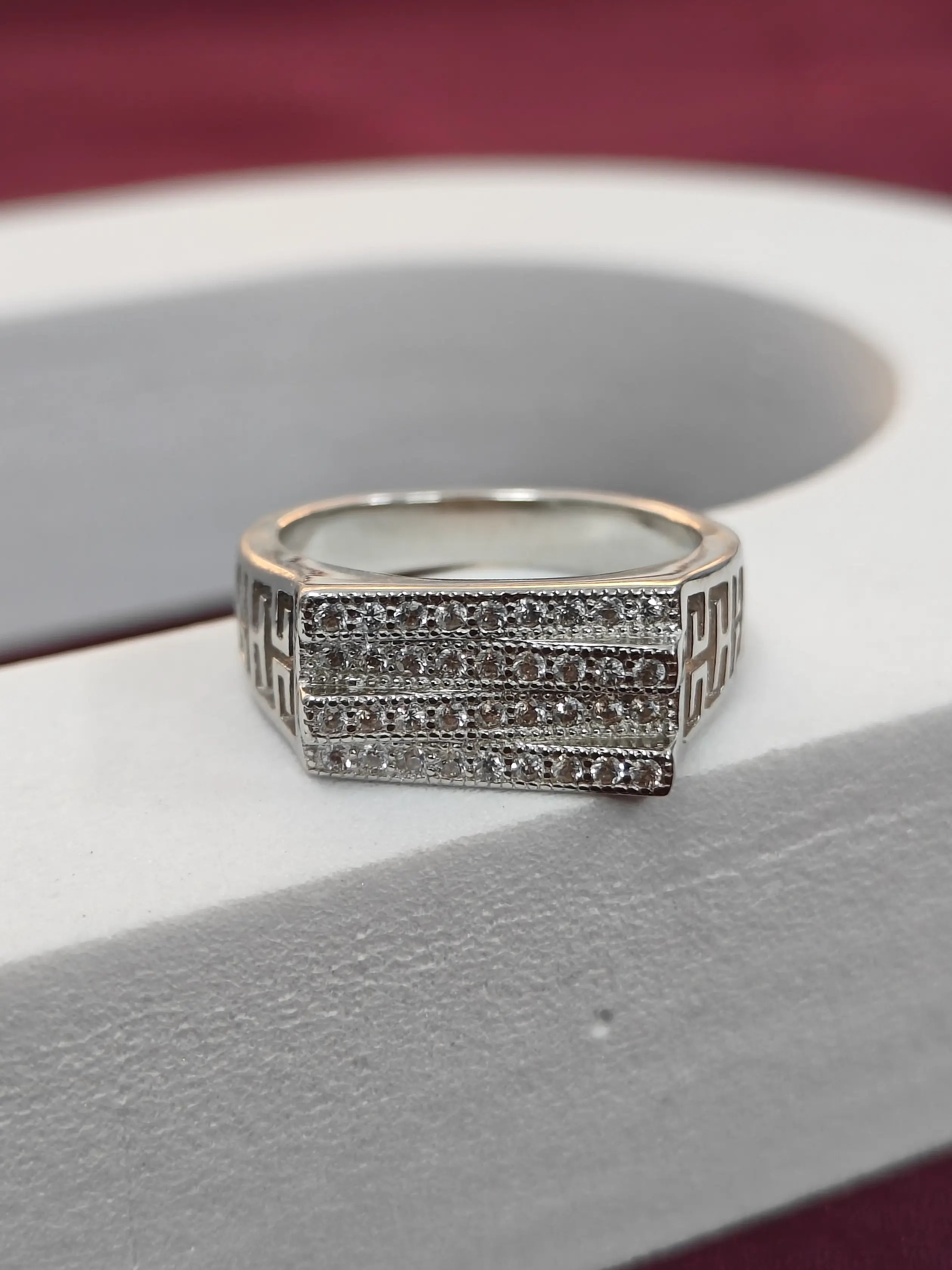 Silver ring with diamond accents on a white surface