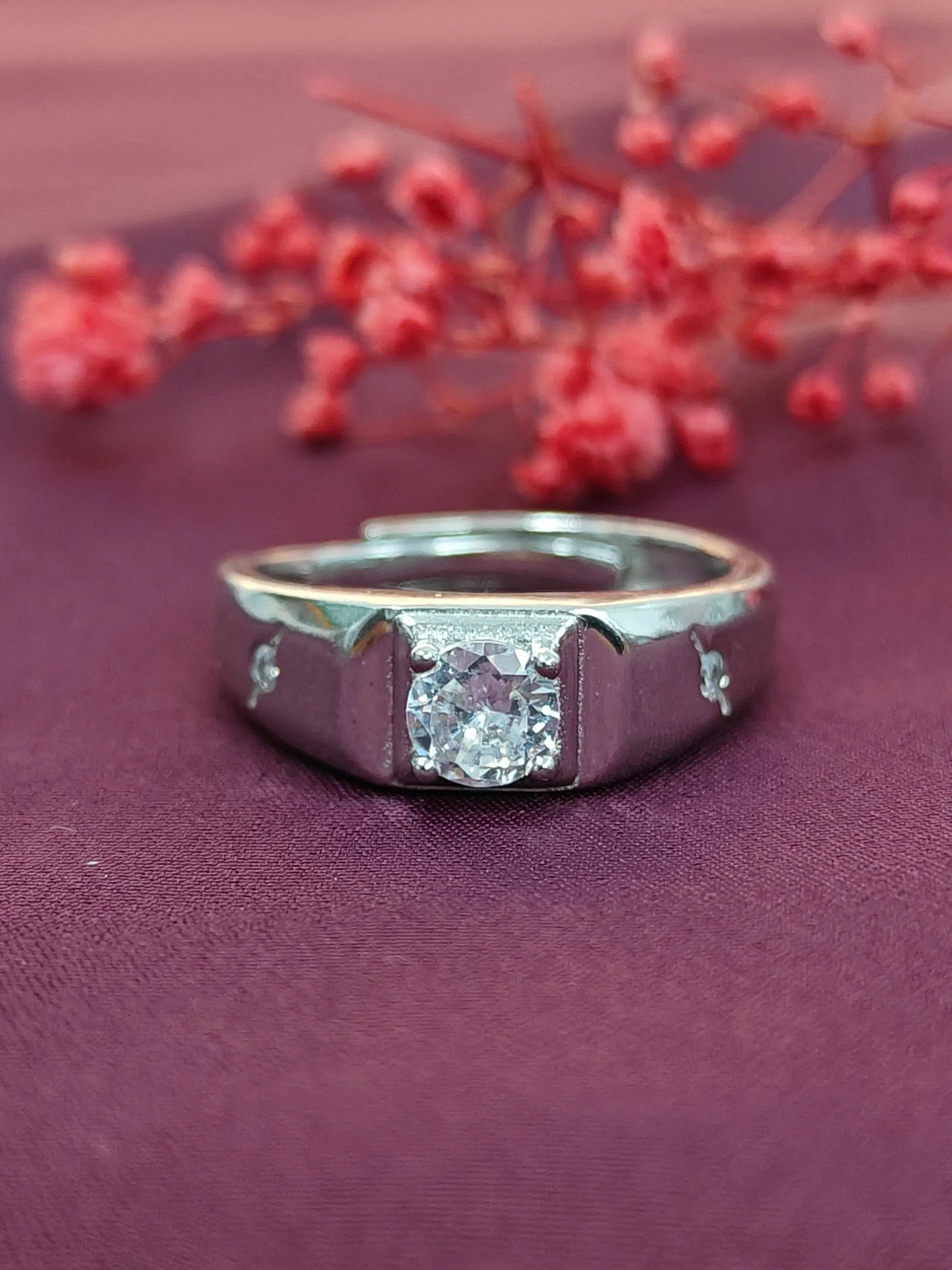 Silver ring with a diamond on a purple fabric background