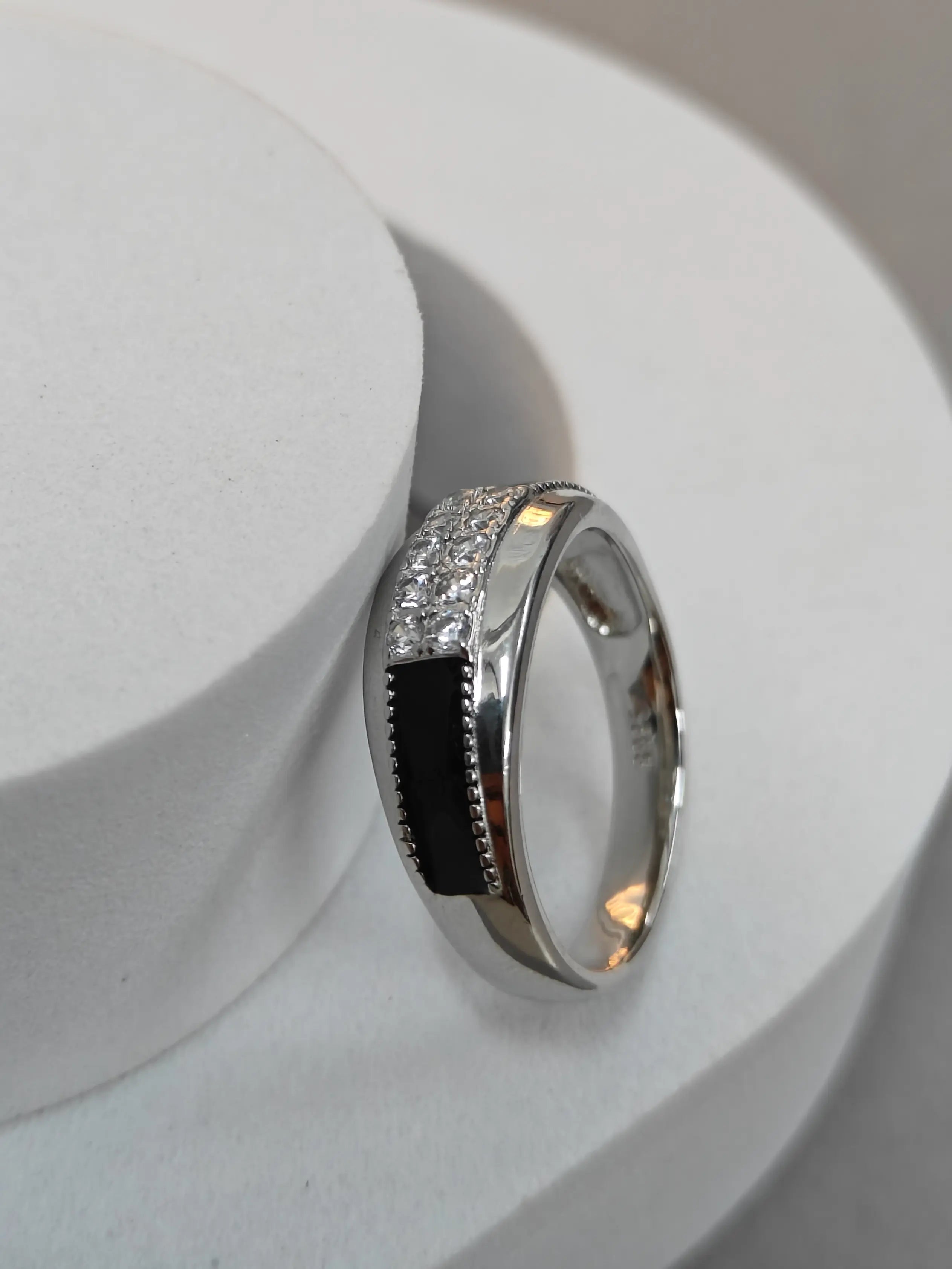 Silver ring with gemstones on a white surface