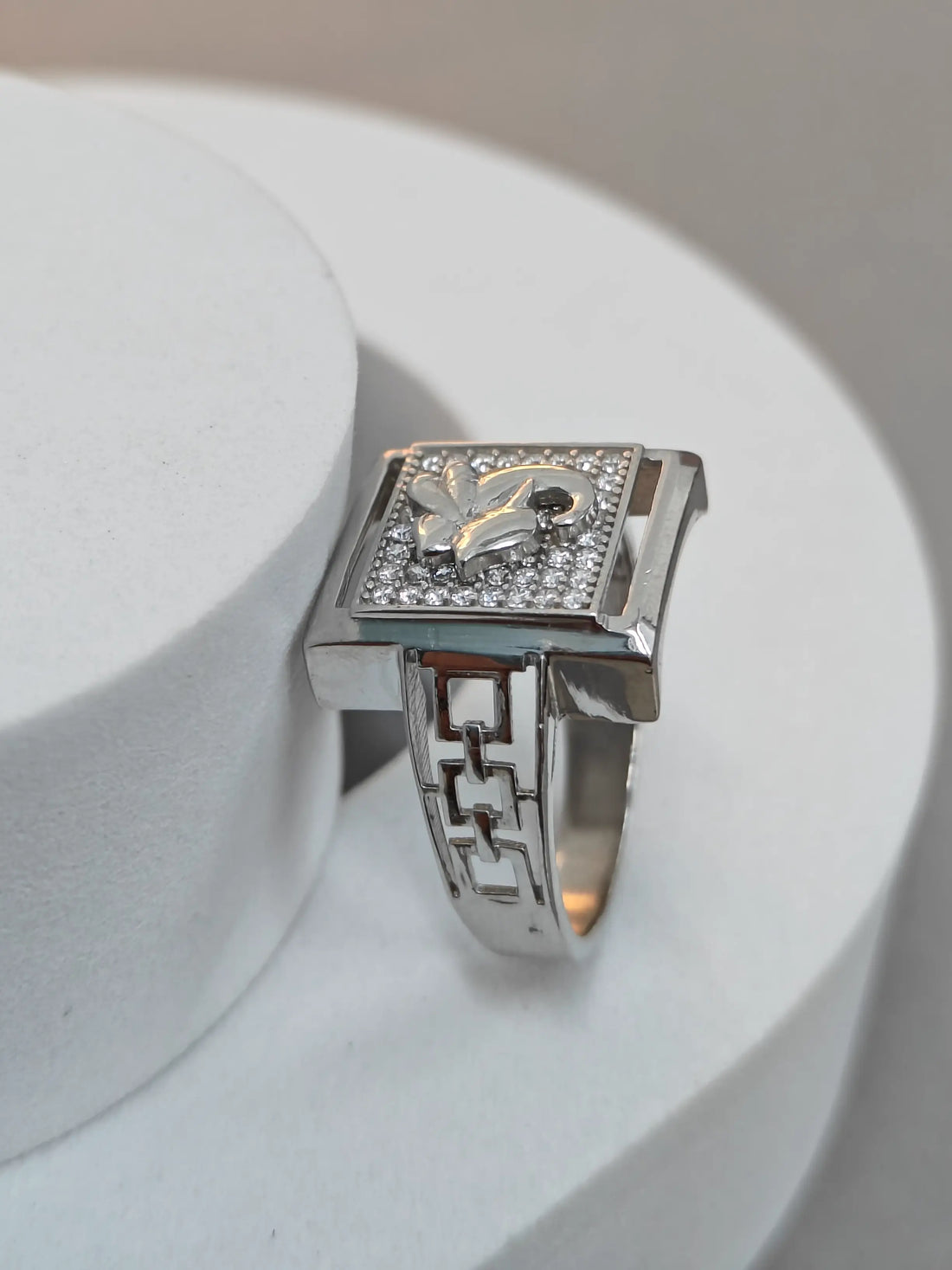 Silver ring with a decorative band on a white surface