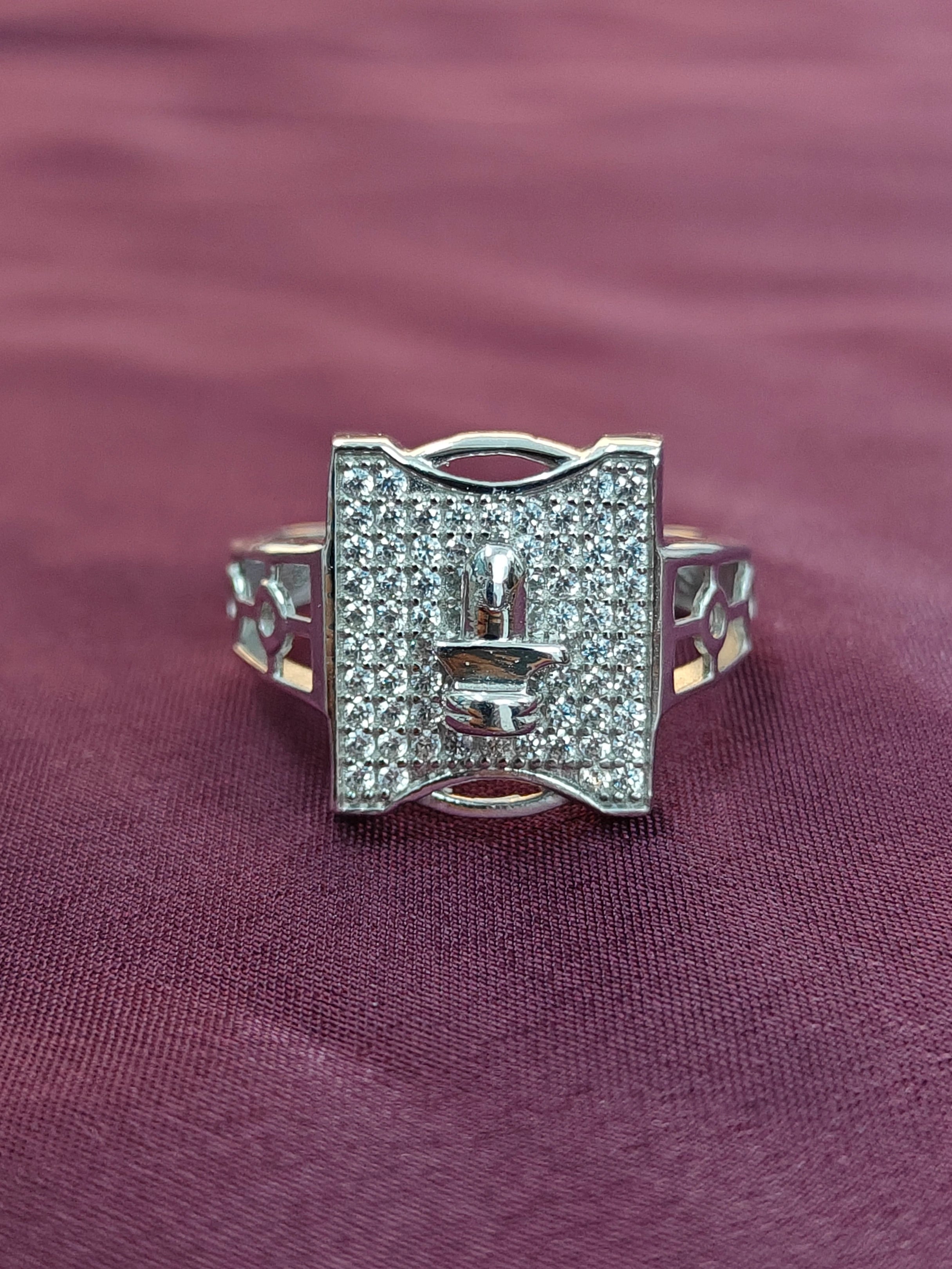 Silver ring with gemstones on a purple fabric background