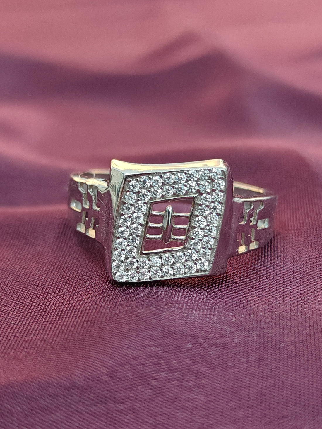 Silver ring with gemstones on a purple fabric background
