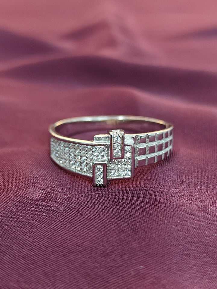 Silver bracelet with geometric design on a maroon fabric background