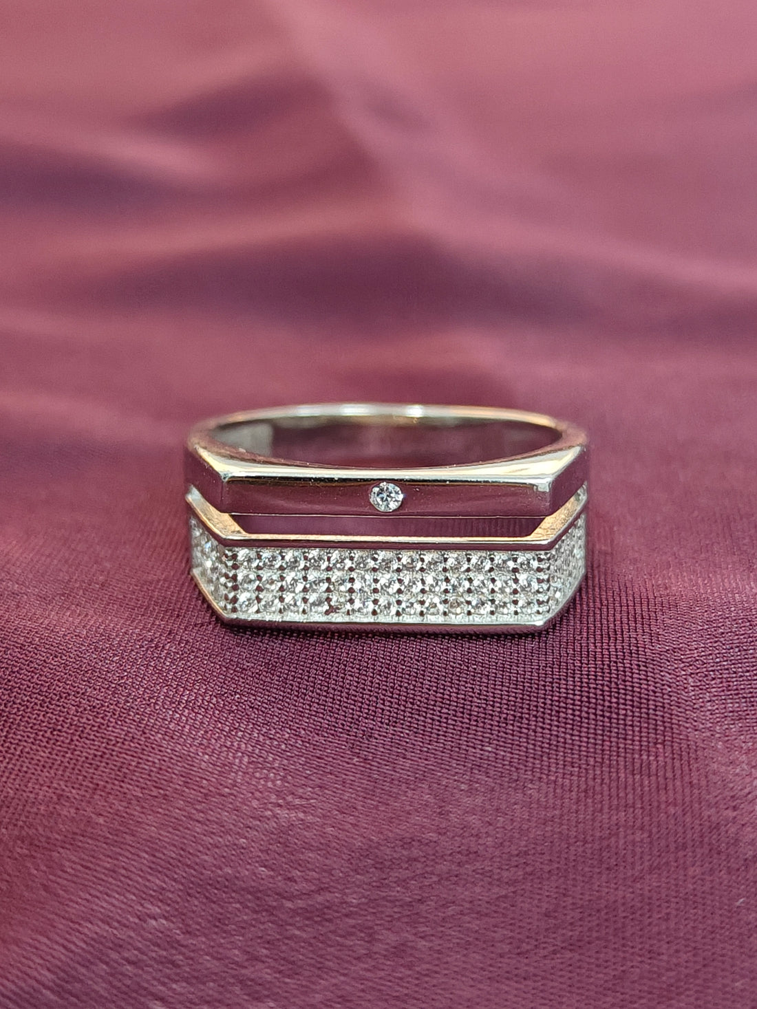 Gold and diamond ring on a maroon fabric background