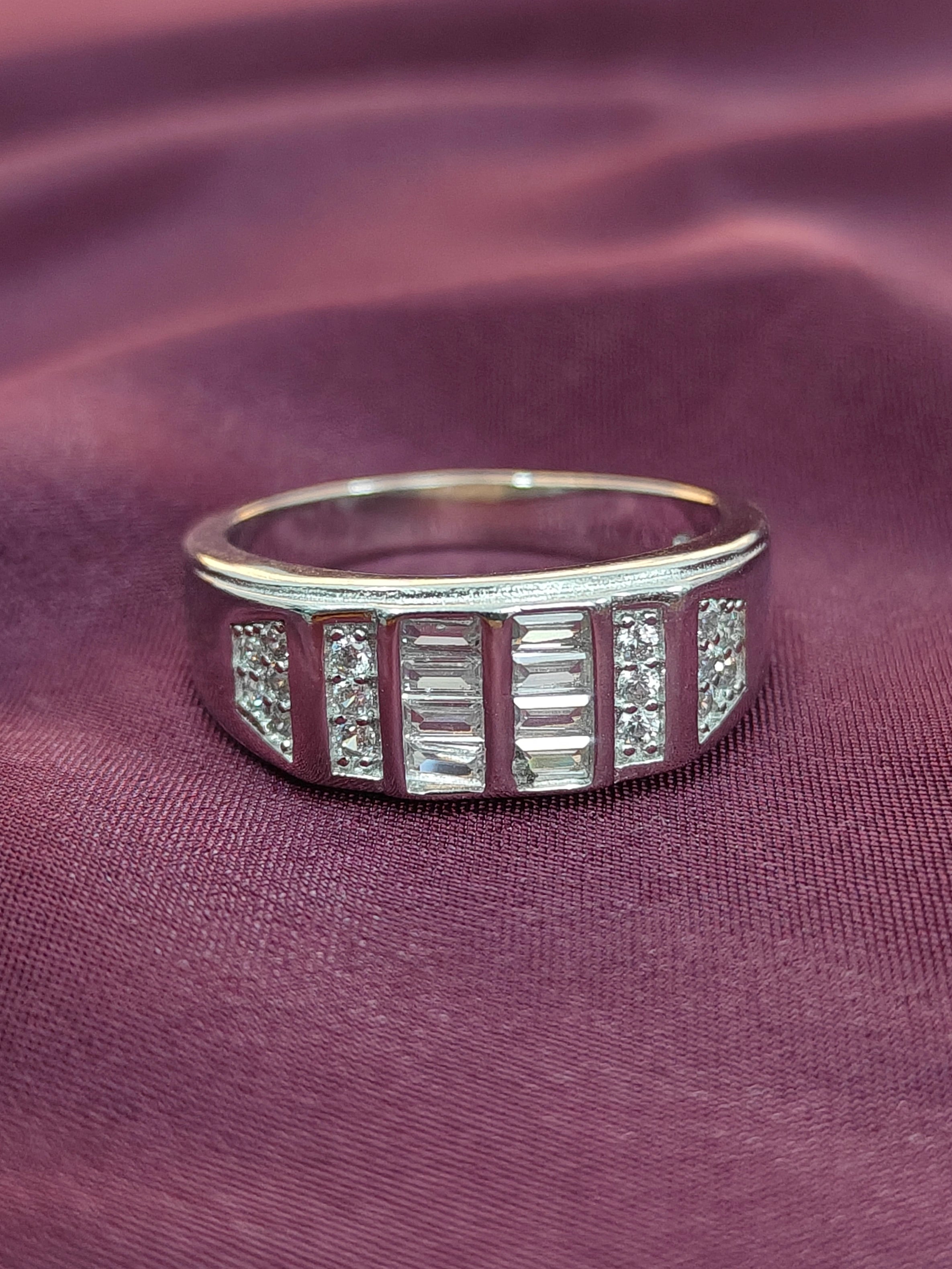 Silver ring with gemstones on a purple fabric background