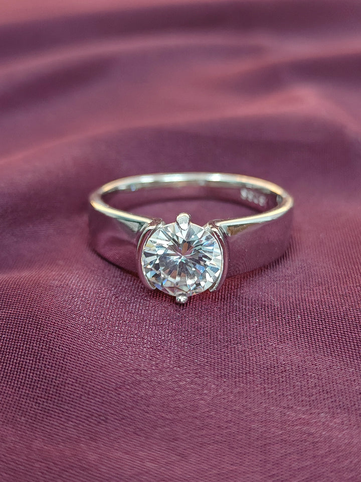 Gold ring with a diamond on a purple fabric background