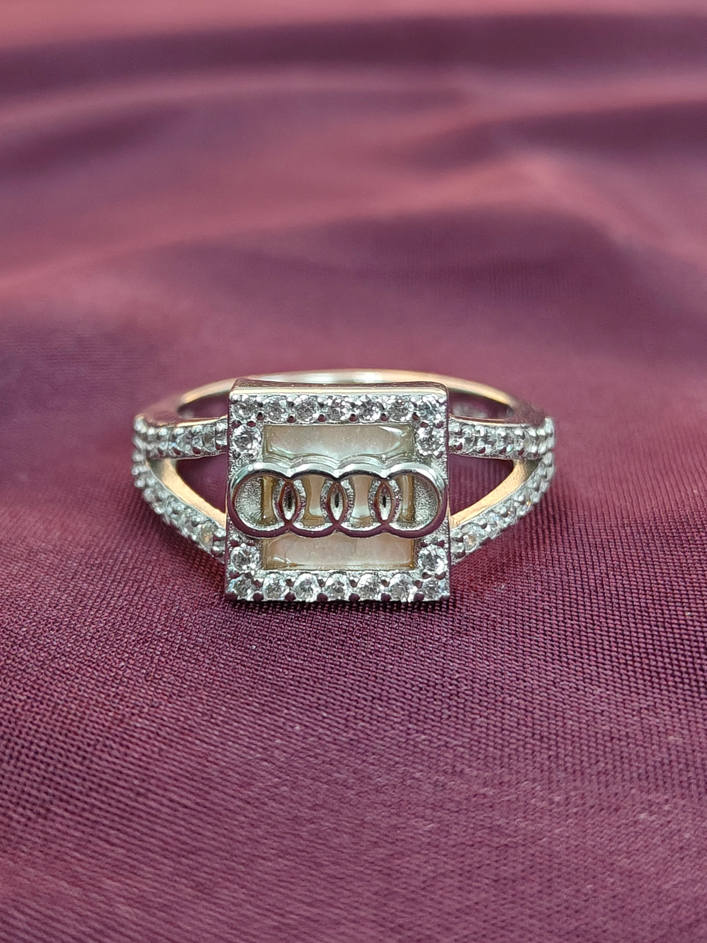 Gold ring with diamond accents on a maroon fabric background