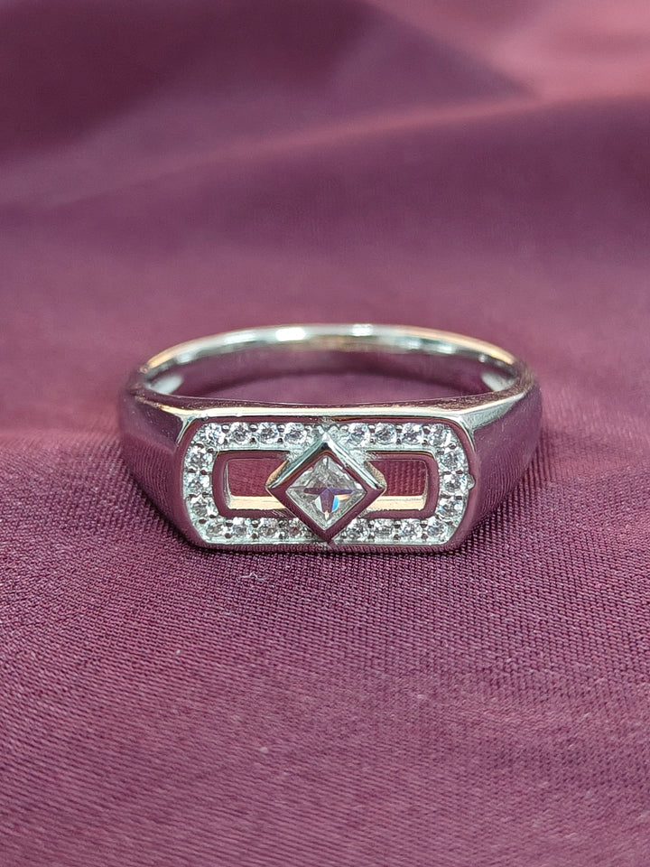 Silver ring with diamond on a purple fabric background