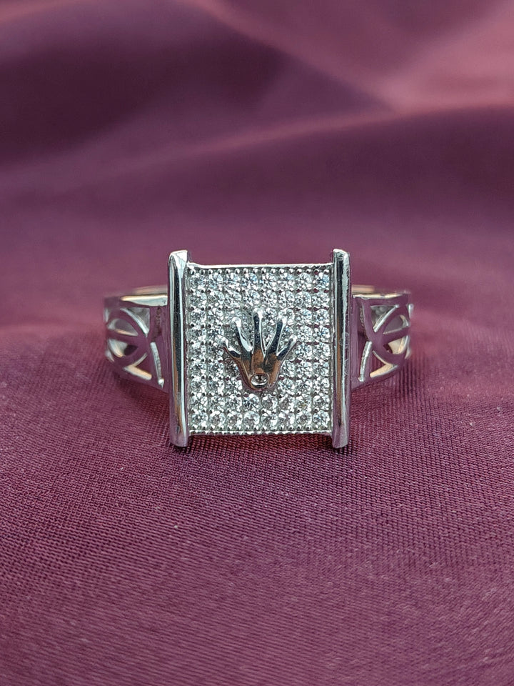 Silver ring with a square diamond setting on a purple fabric background
