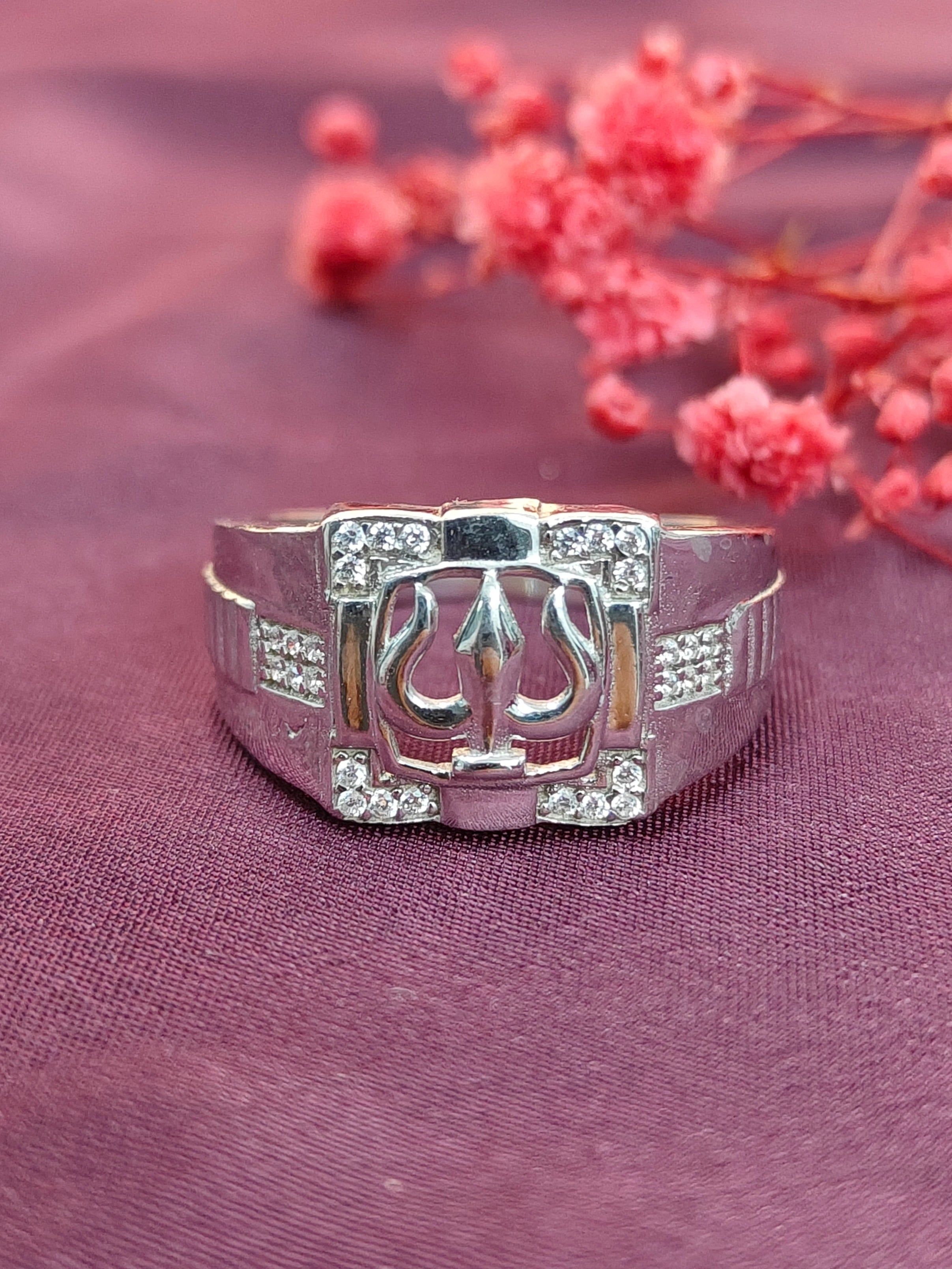 Silver bracelet with a decorative clasp on a purple fabric background