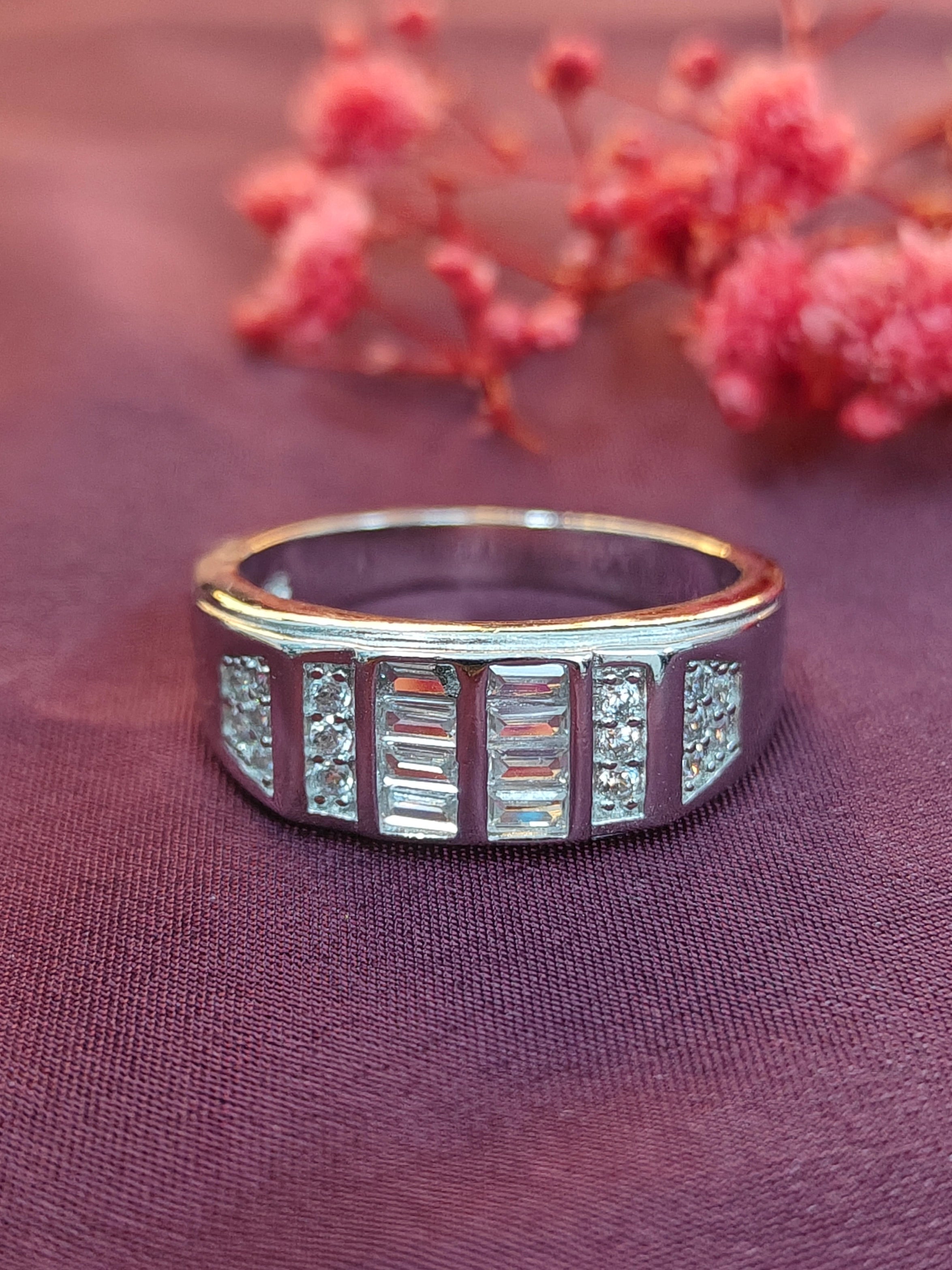 Silver ring with gemstones on a purple fabric background