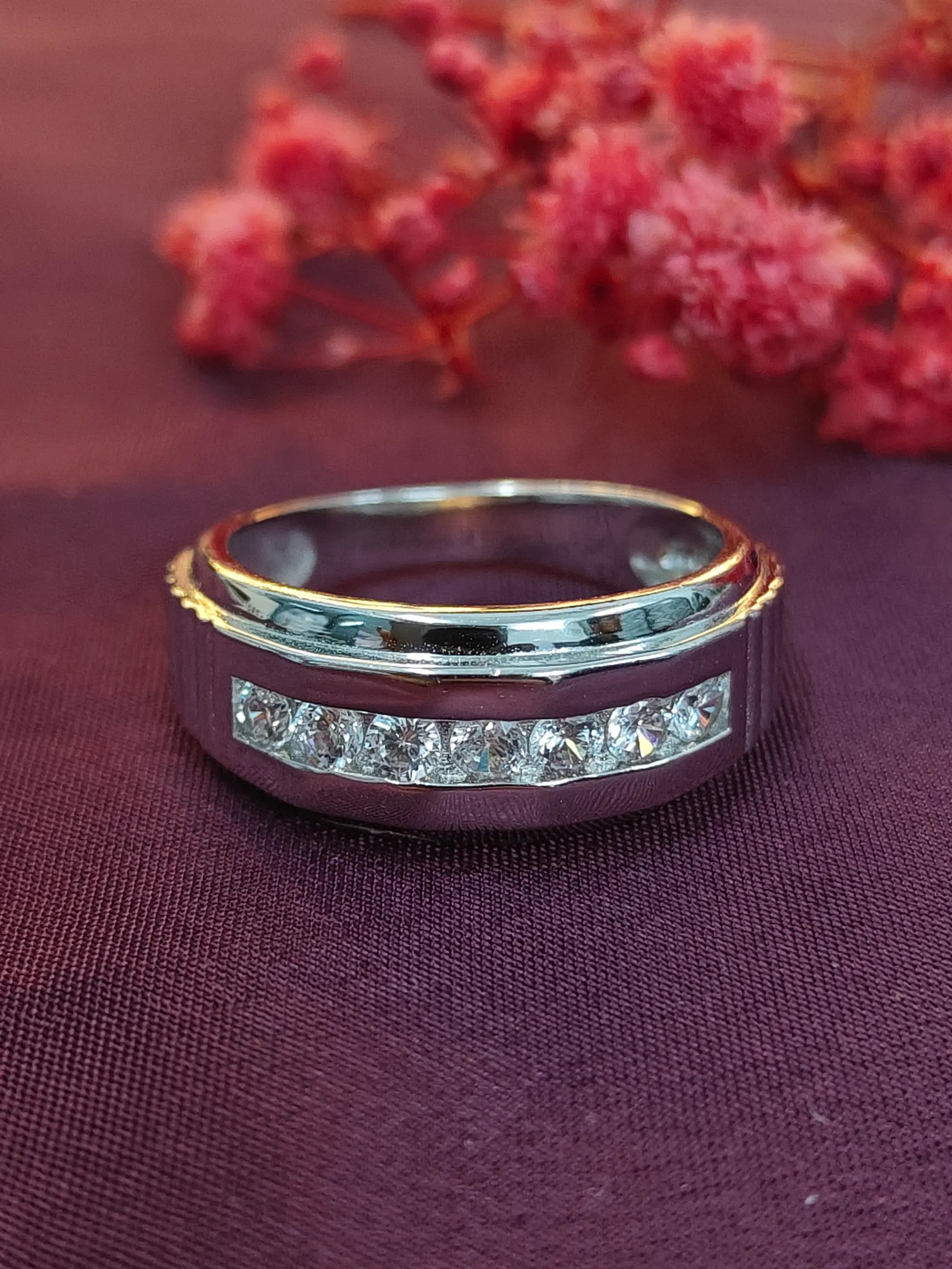 Gold and silver ring with gemstones on a purple fabric background