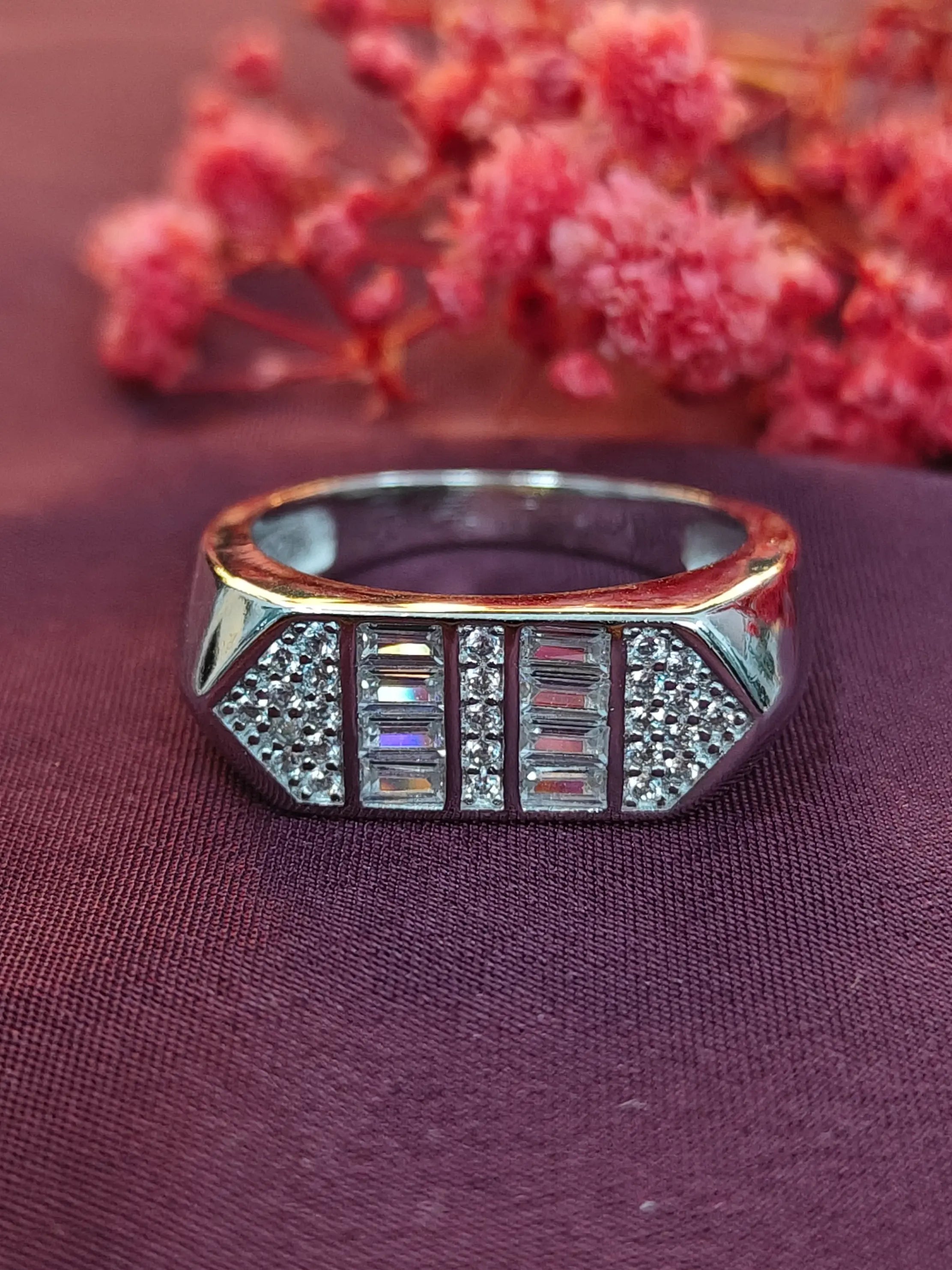 Silver ring with gemstones on a purple fabric background