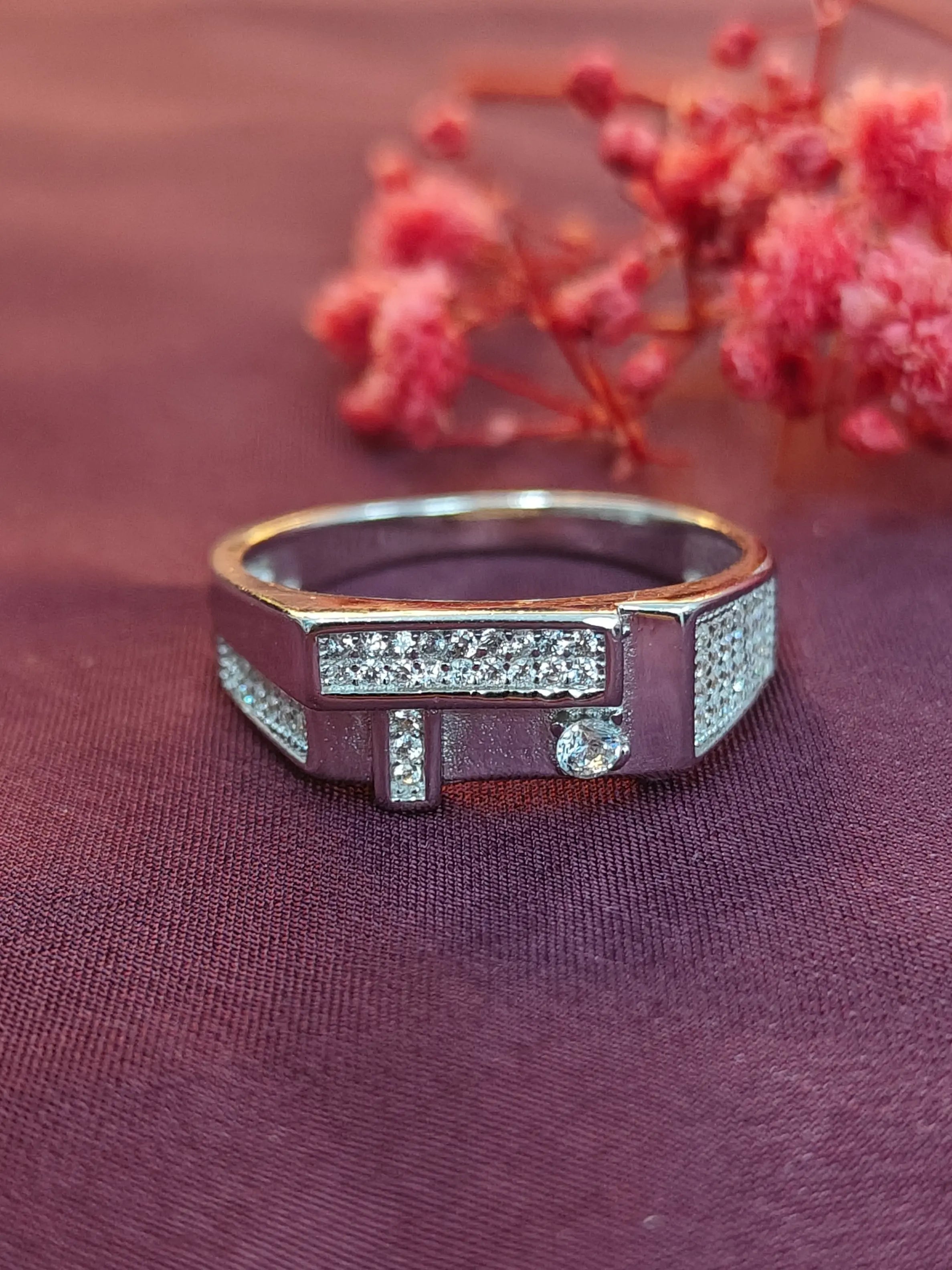 Silver ring with gemstones on a purple fabric background