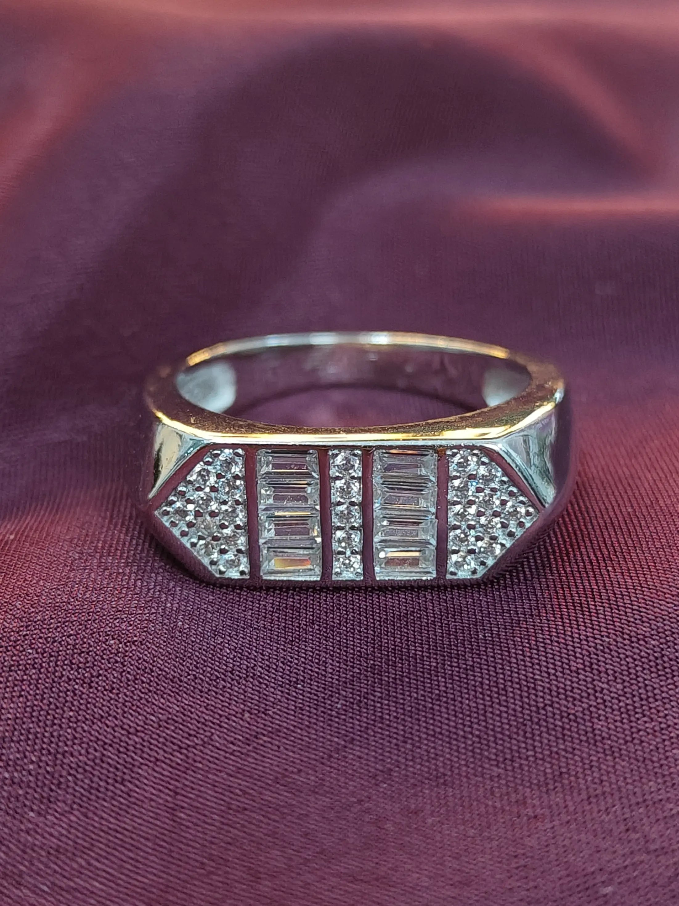 Silver ring with gemstones on a purple fabric background