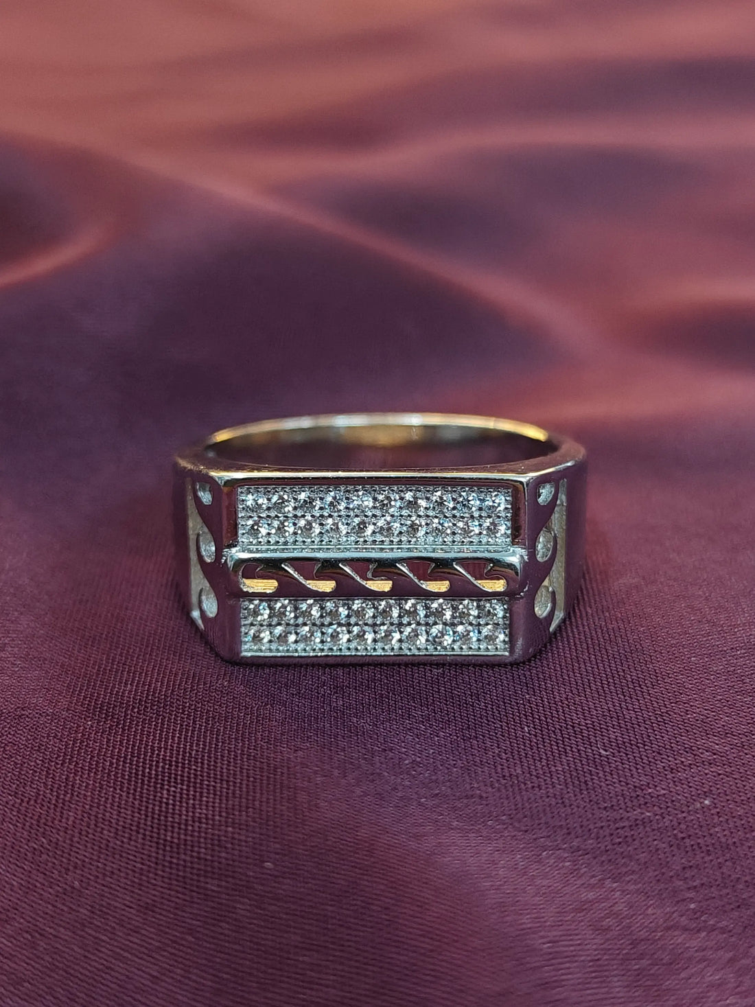 Gold and silver ring on a textured purple fabric background