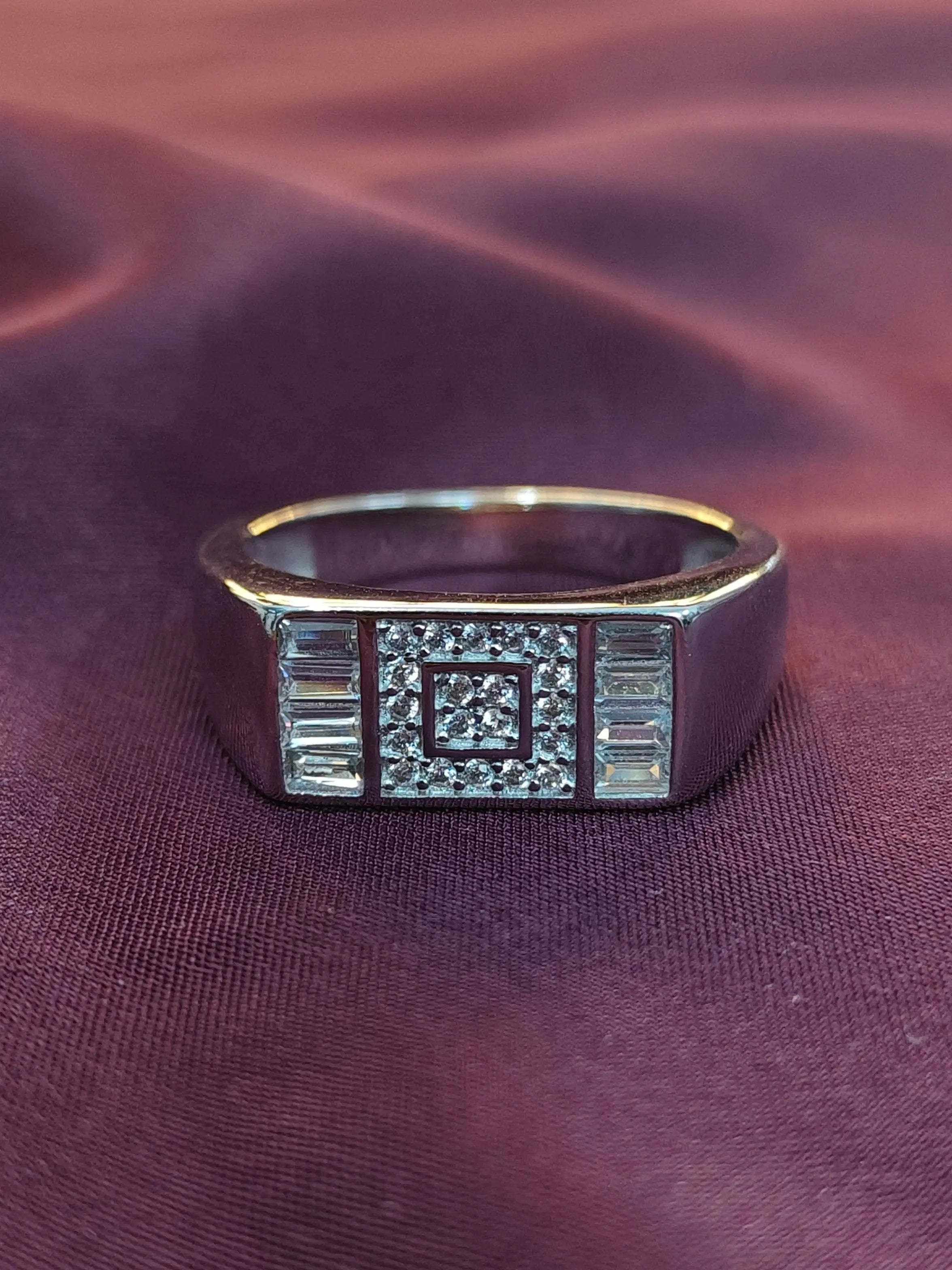 Silver ring with gemstones on a purple fabric background