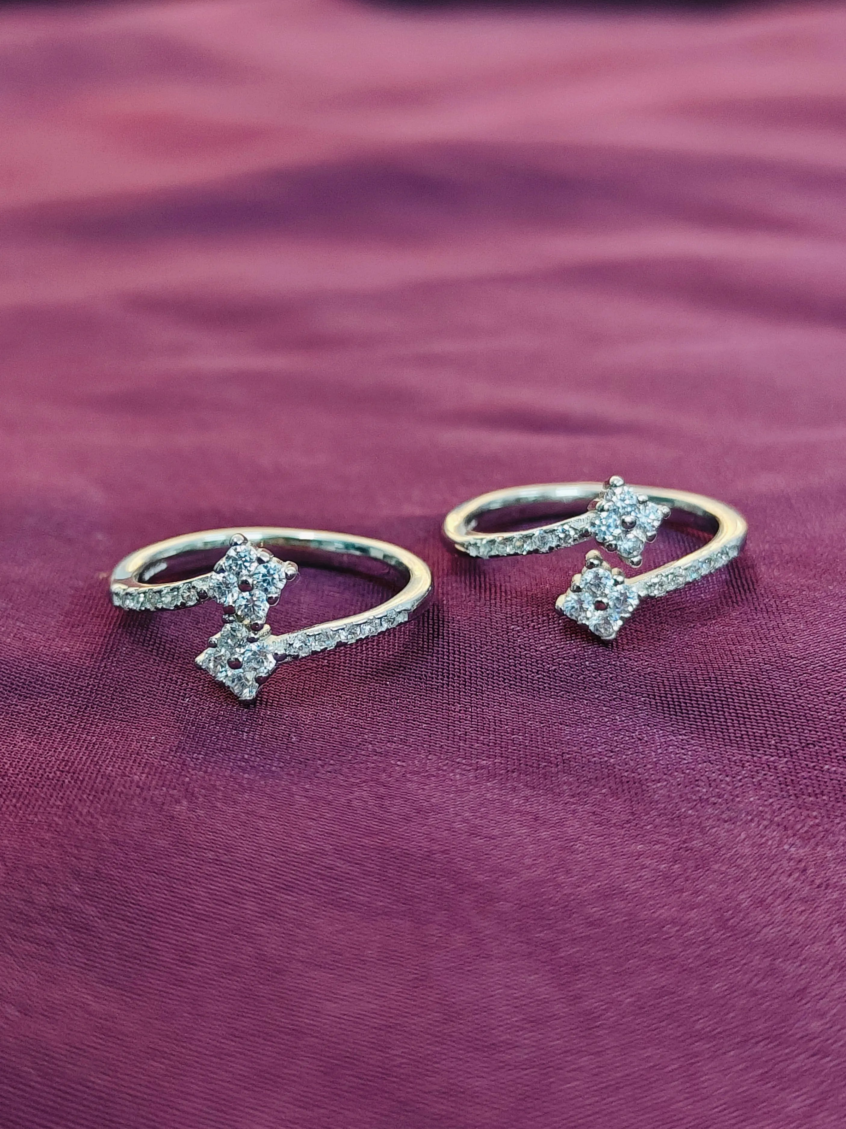 Two diamond rings on a purple fabric background