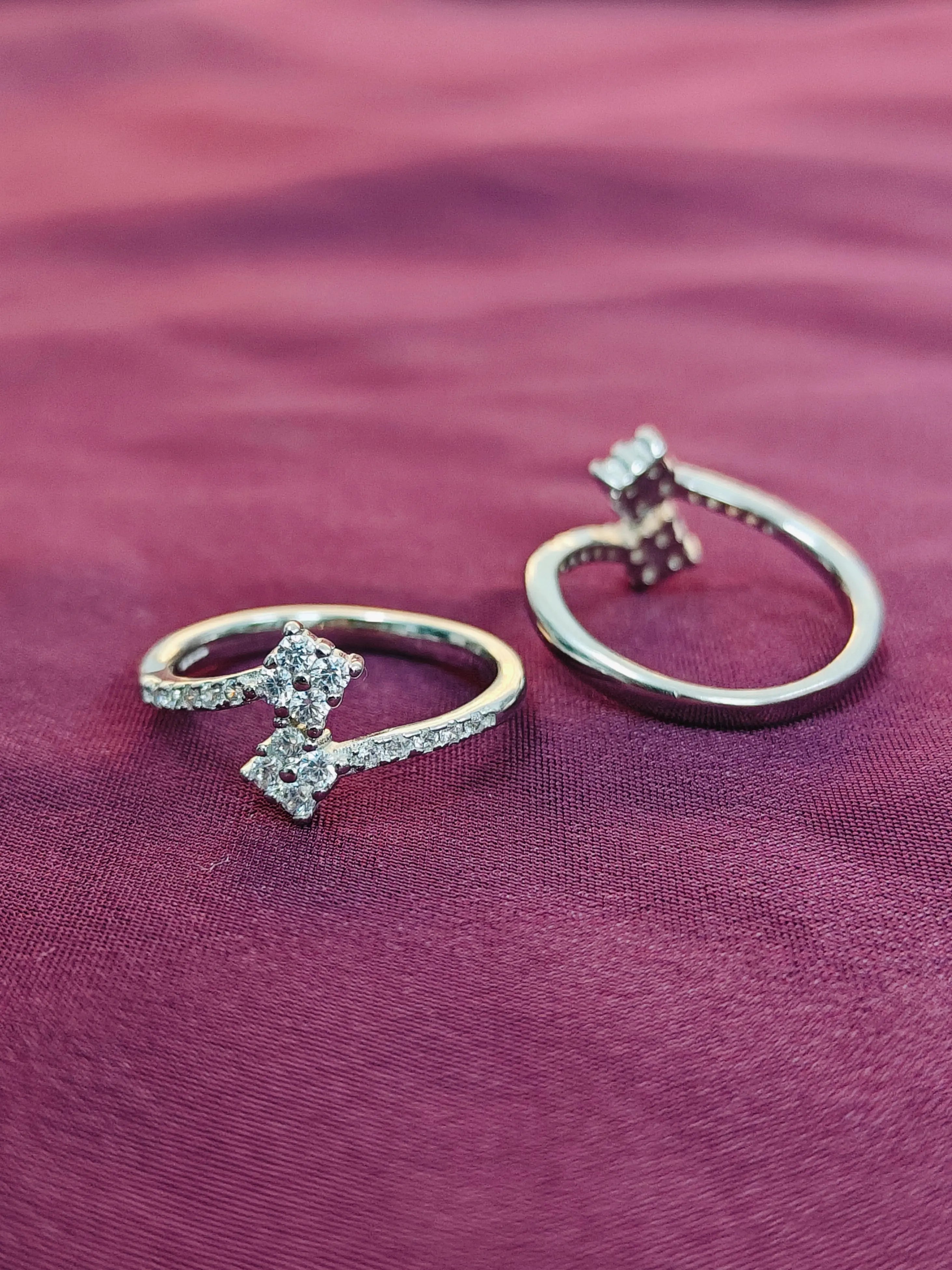 Two diamond rings on a purple fabric background