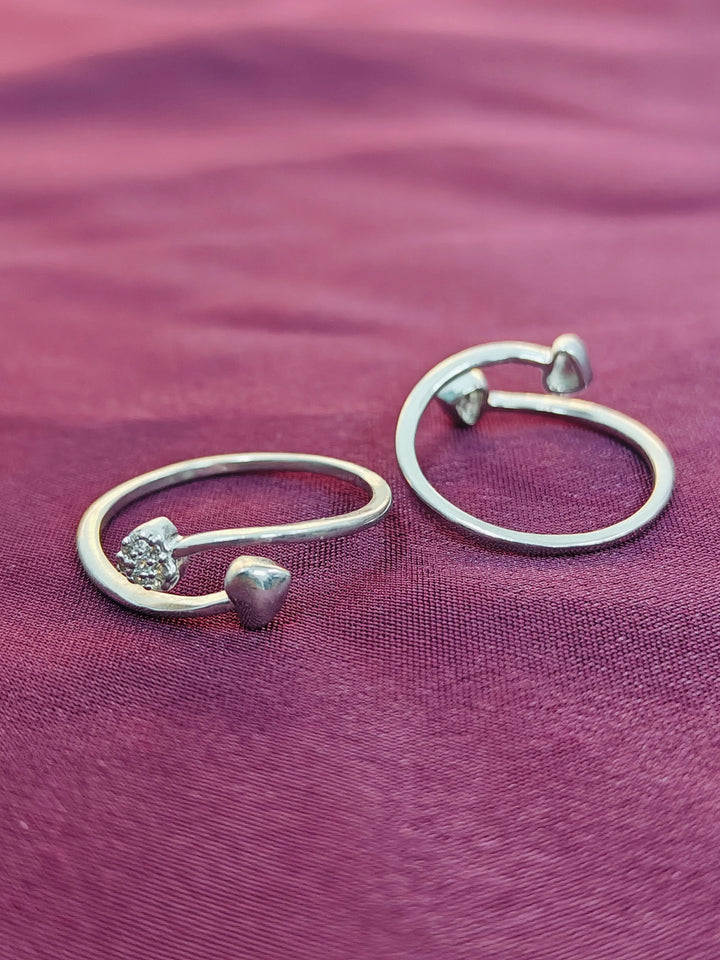 Pair of silver hoop earrings on a purple fabric background