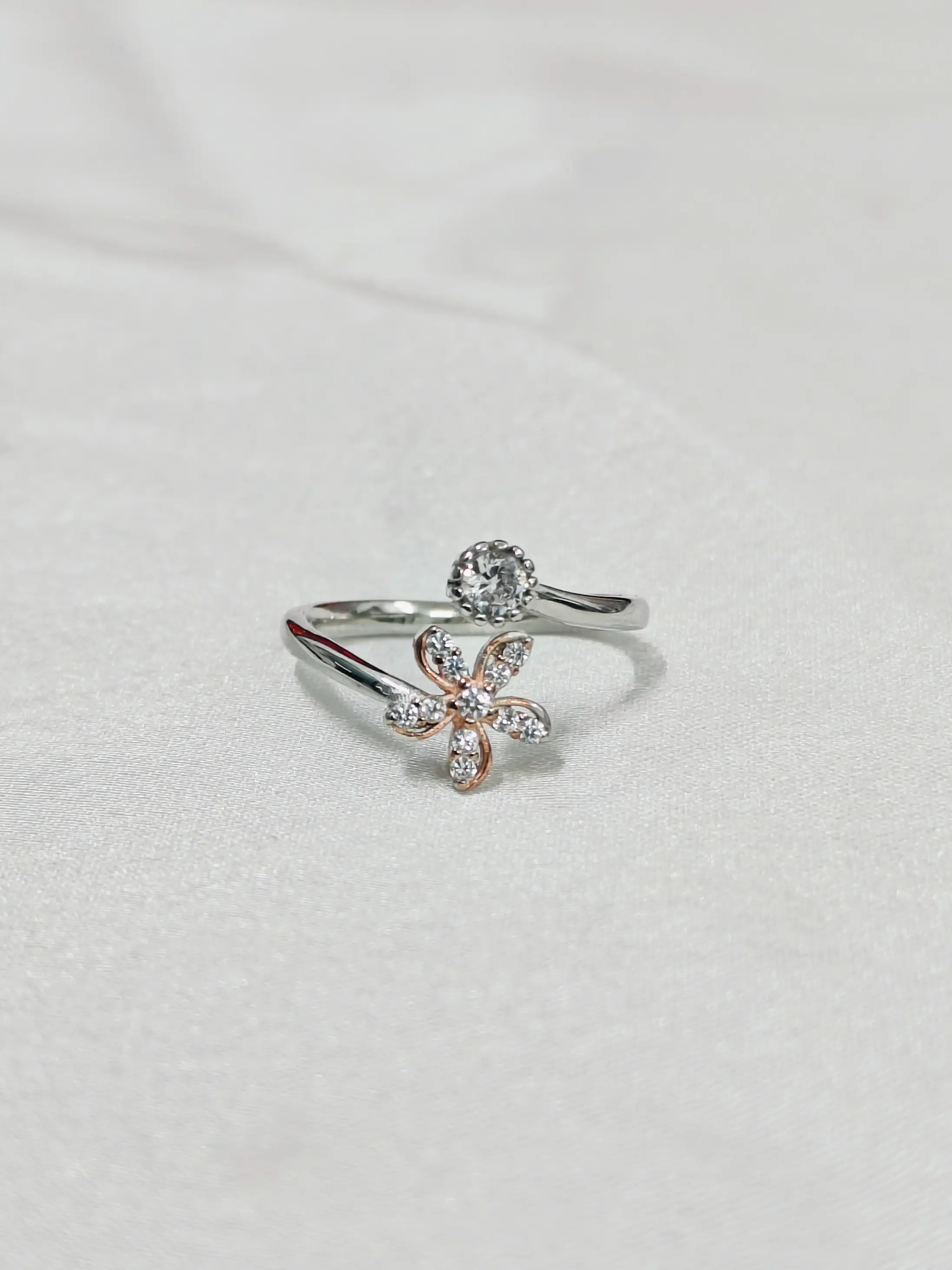 Silver ring with a floral design on a light gray background